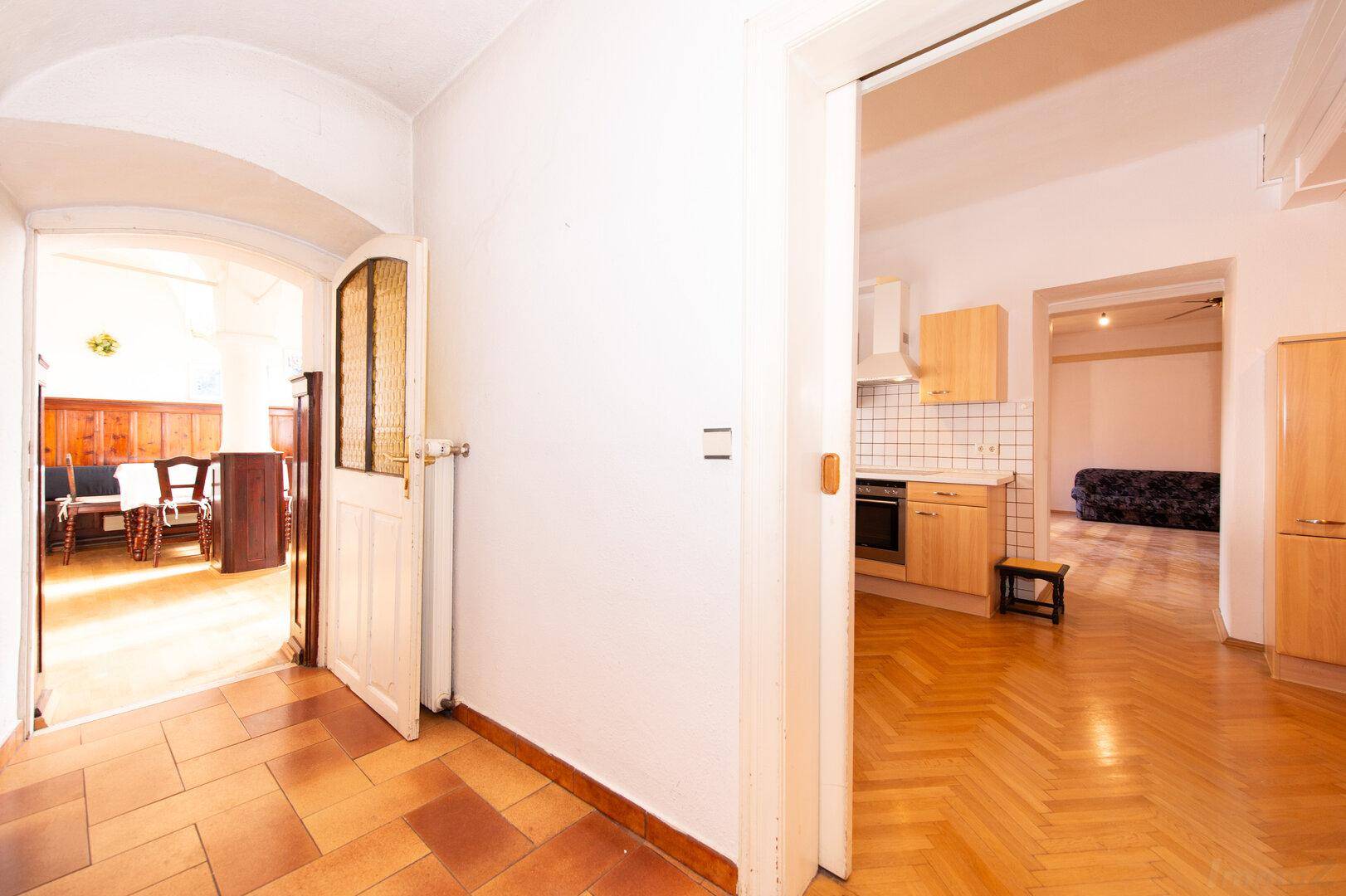 Heller Flur mit Terrakotta-Fliesenboden, der zu einer Küche und einem weiteren Zimmer führt.