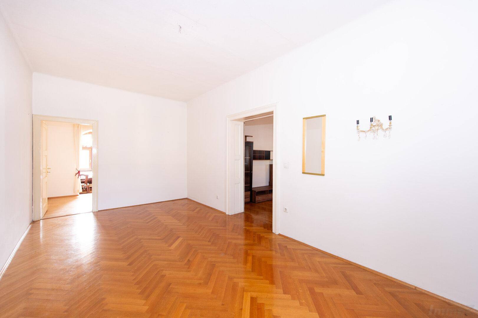 Helles Wohnzimmer mit Fischgrätparkett und minimalistischer Einrichtung.