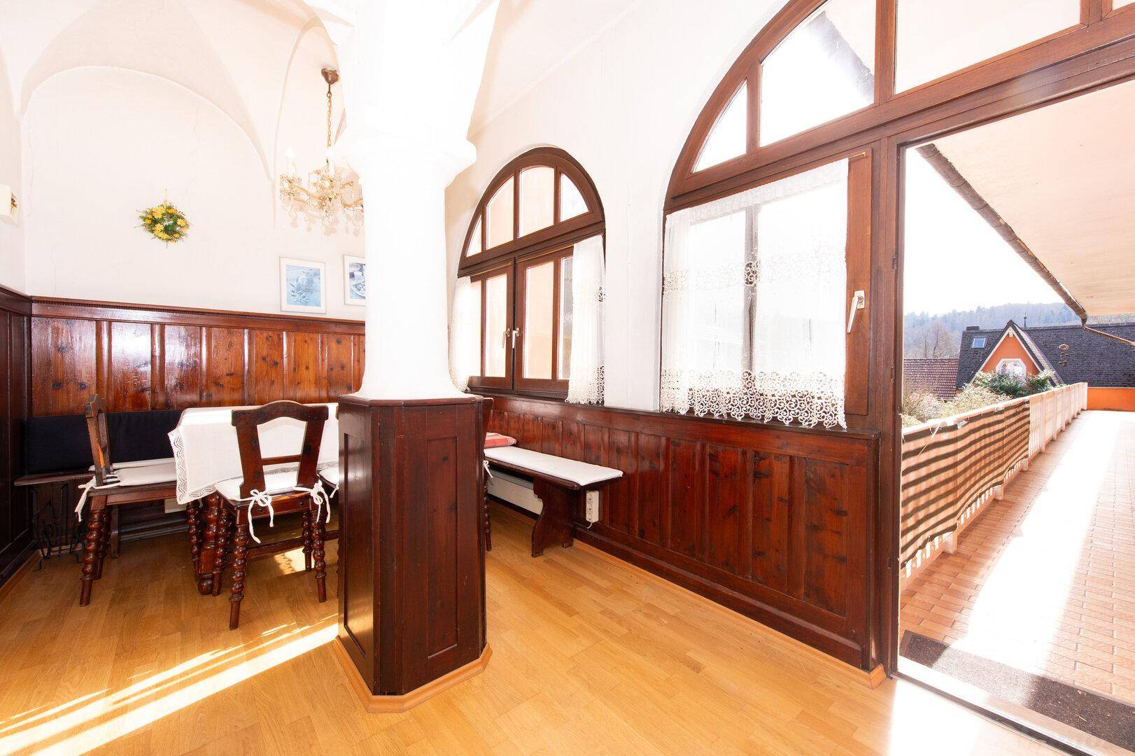 Essbereich mit Holztäfelung, Gewölbedecke und Zugang zu einem langen Balkon.