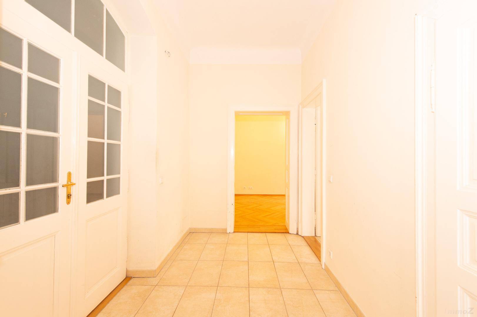 Langer, heller Flur mit Fliesenboden und Türen zu weiteren Zimmern der Wohnung.