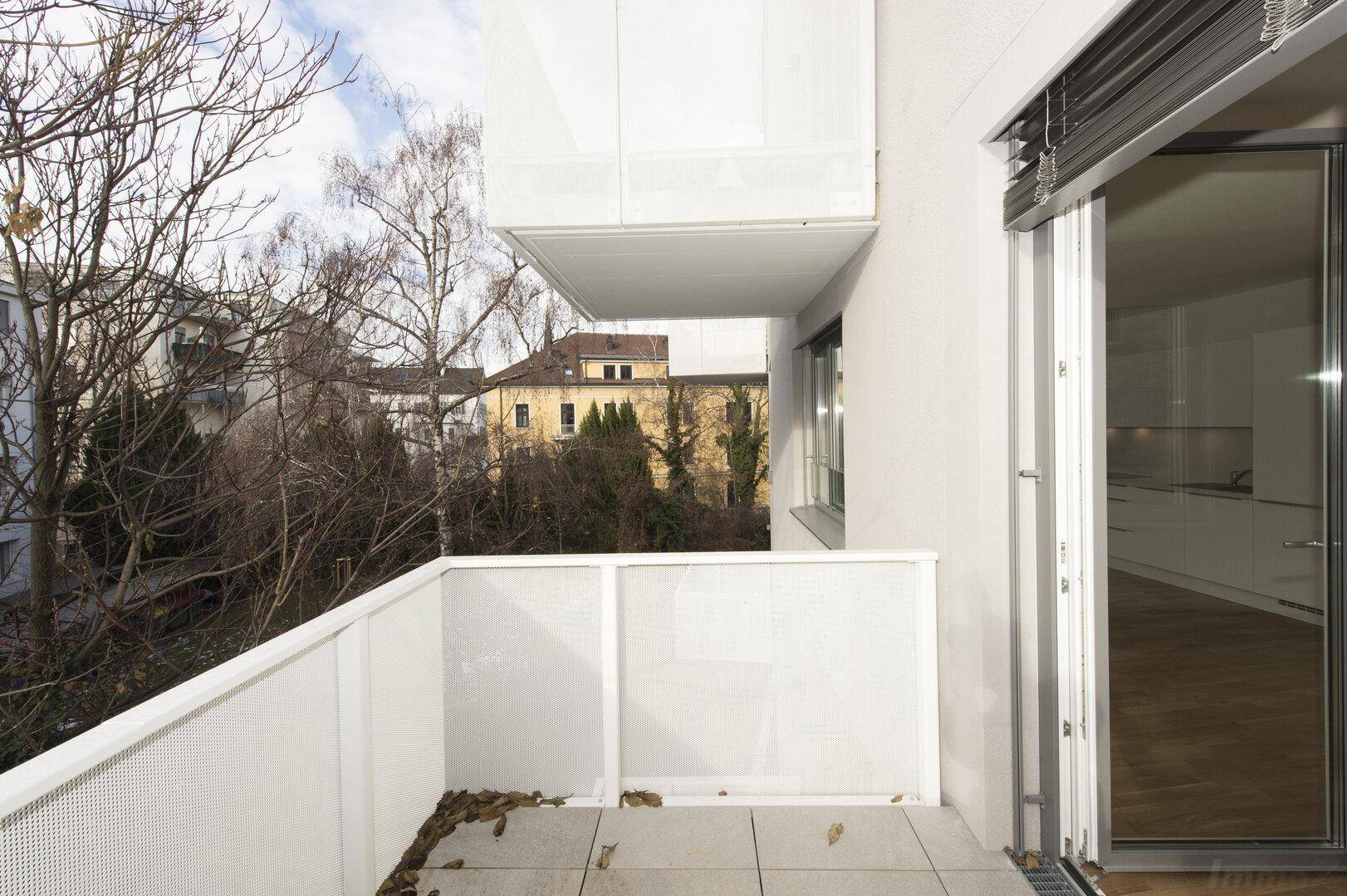 Balkon mit Blick auf die Nachbarschaft und einen Teil der modernen Küche im Innenbereich.