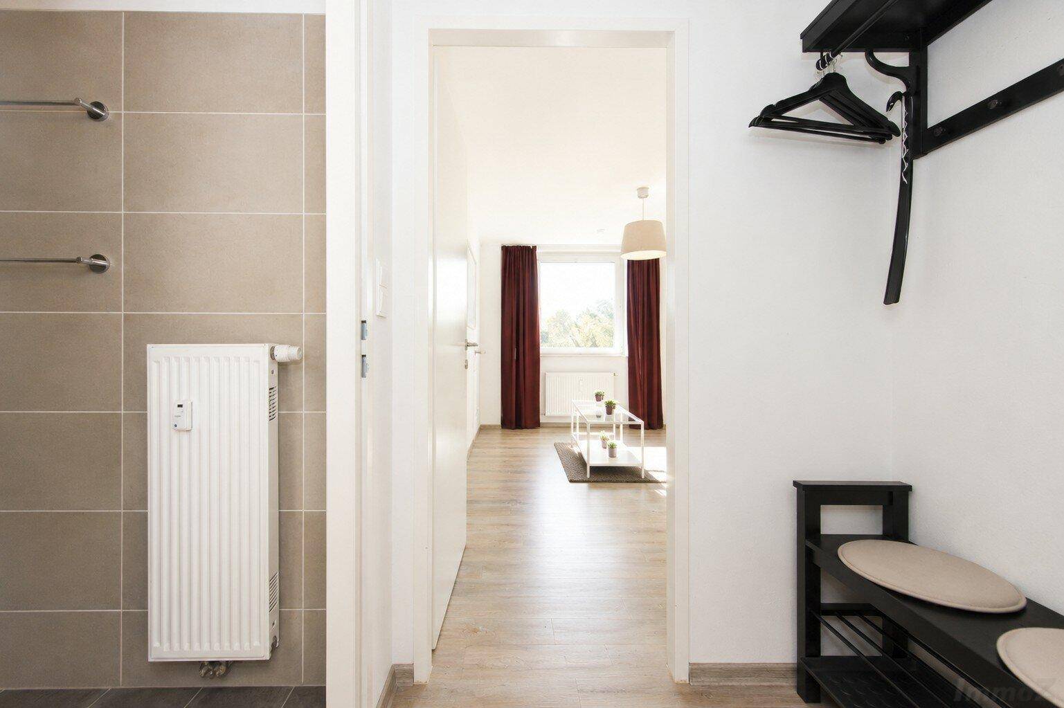 Flur mit Garderobe und Blick in den hellen Wohnbereich.