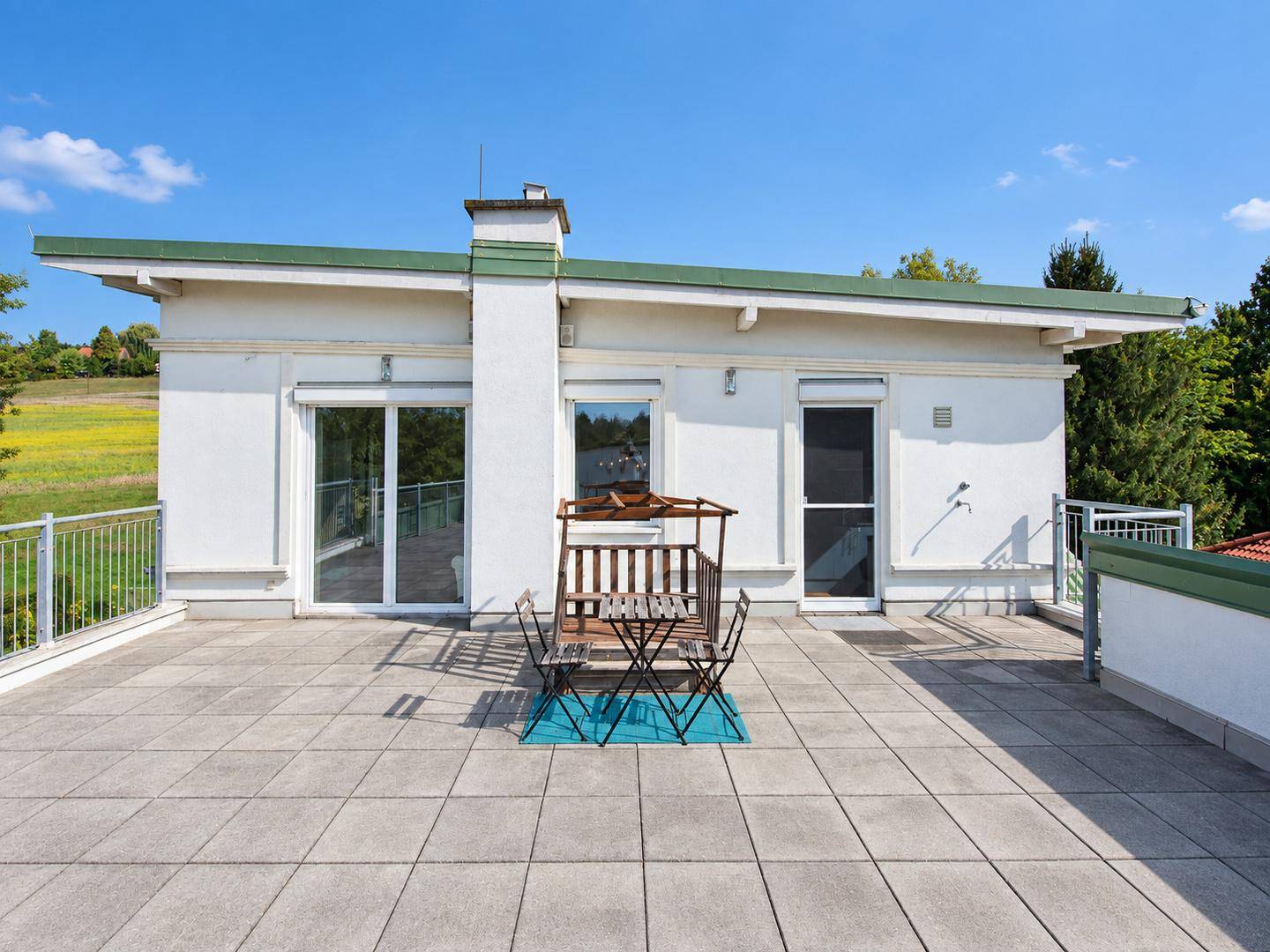Geräumige Dachterrasse mit Sitzgruppe und Blick auf die umliegende Landschaft.
