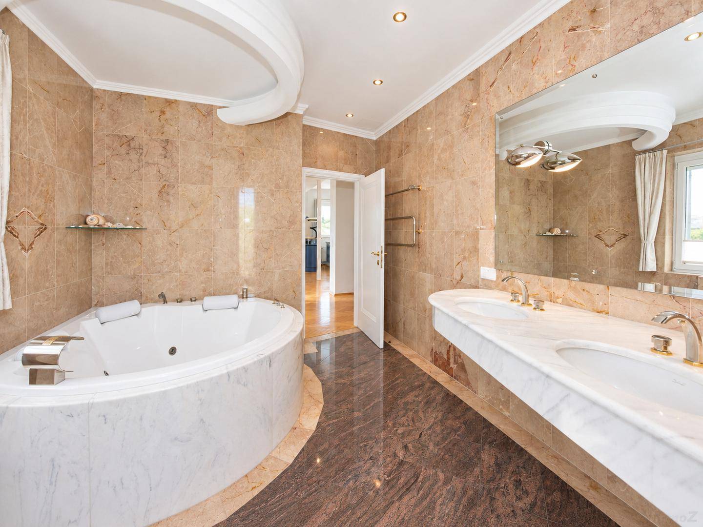Elegantes Badezimmer mit Marmorfliesen, großem Whirlpool und Doppelwaschbecken.