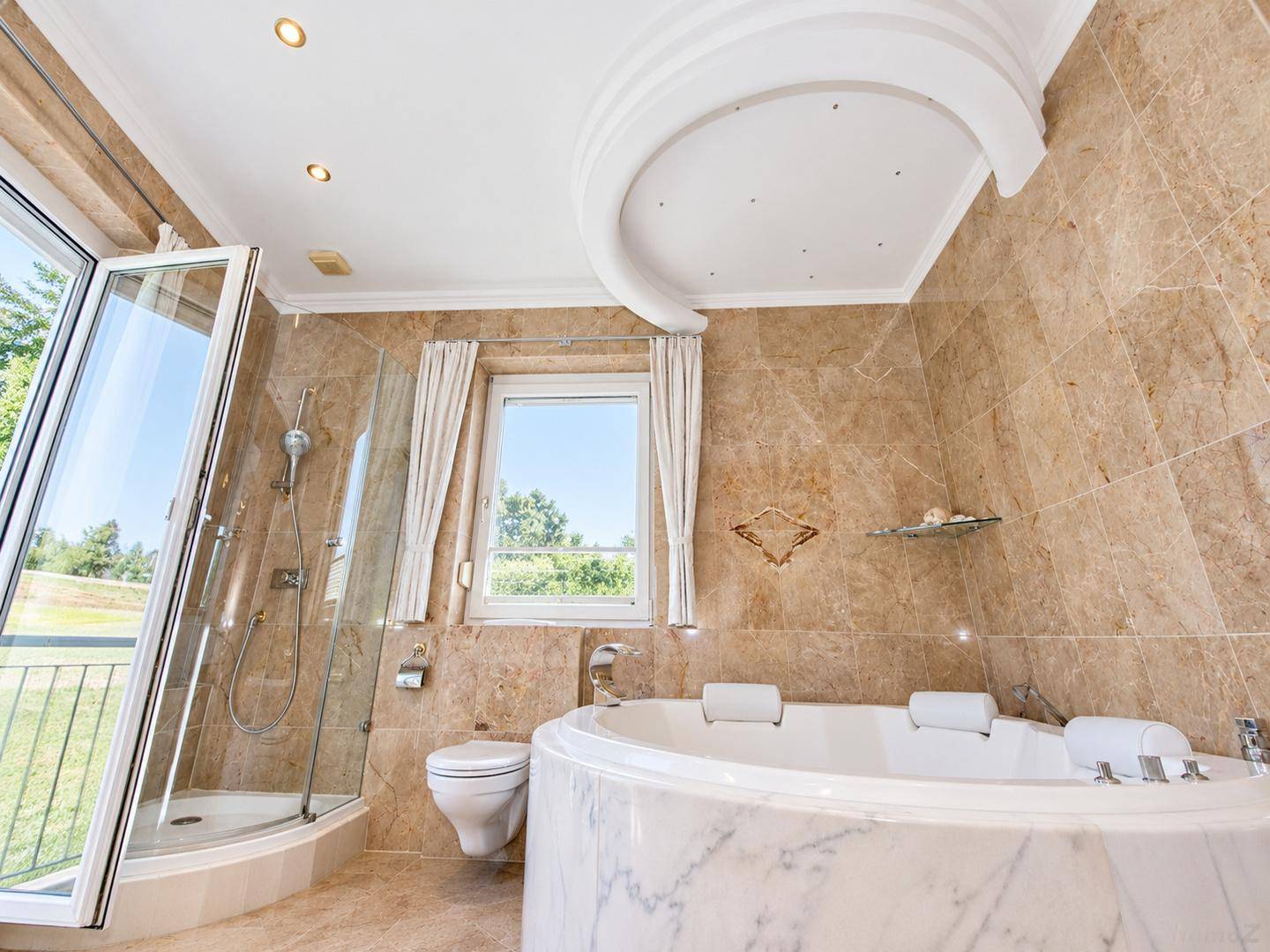 Elegantes Badezimmer mit Whirlpool, Dusche, WC und Fenster mit Blick ins Grüne.