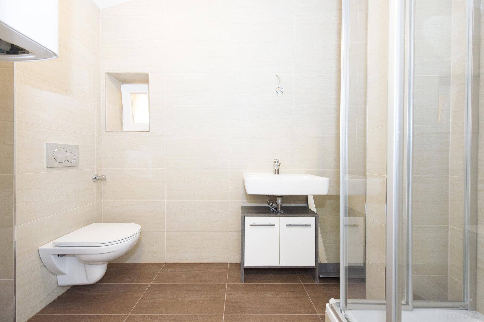 Modernes Badezimmer mit Dusche, wandhängendem WC und Waschbecken.