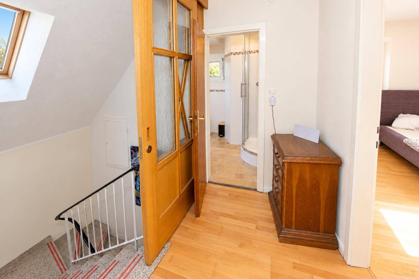 Oberer Flurbereich mit Holzboden, Zugang zu Bad und Schlafzimmer unter Dachschräge.
