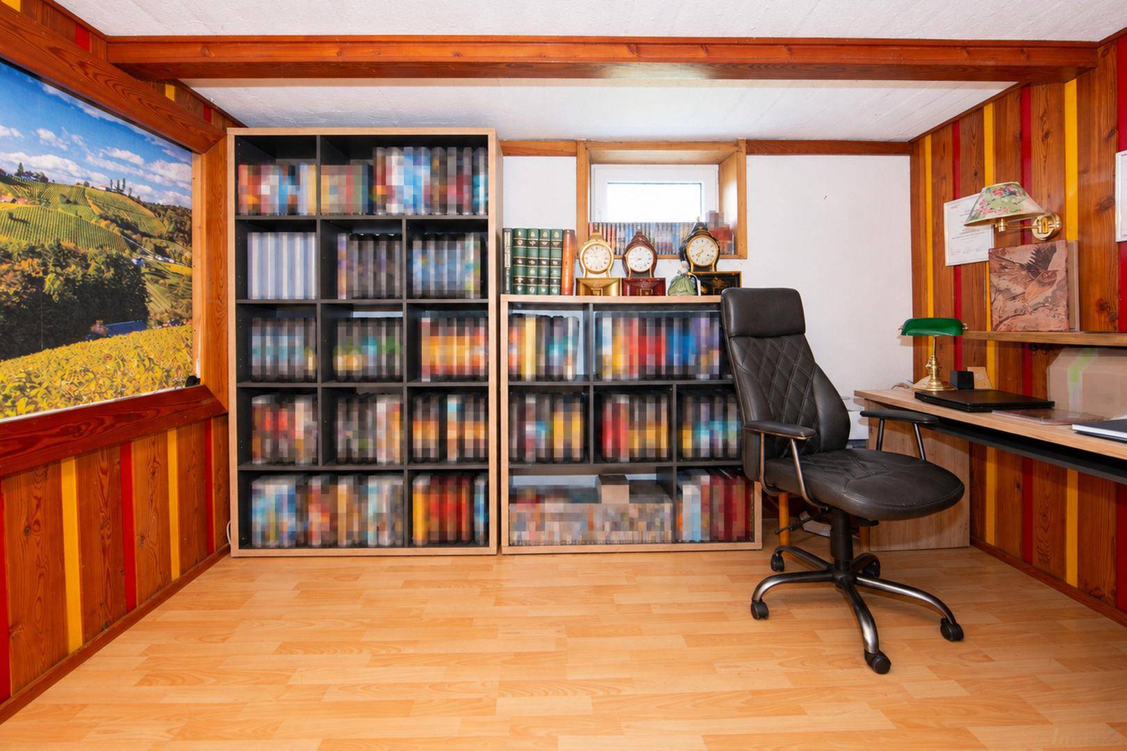 Arbeitszimmer mit Holzboden, Holzvertäfelung, sichtbaren Deckenbalken und Bücherregalen.