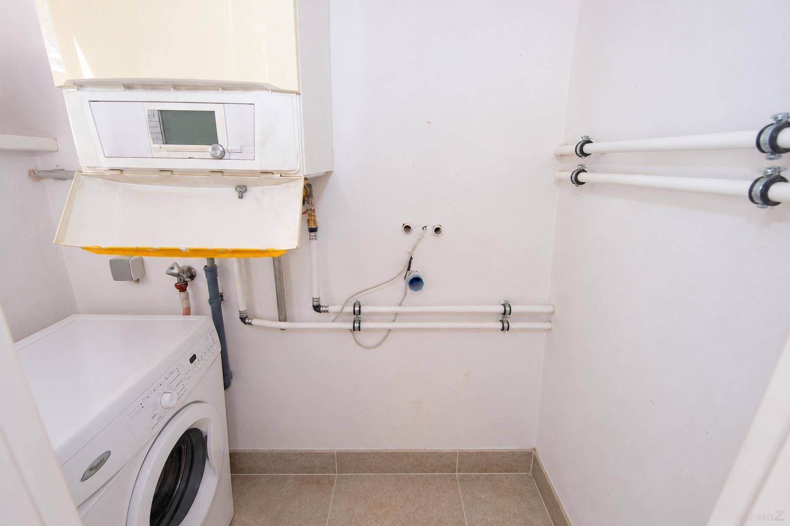 Hauswirtschaftsraum mit Gastherme und Waschmaschine, Anschlüsse für weitere Geräte.