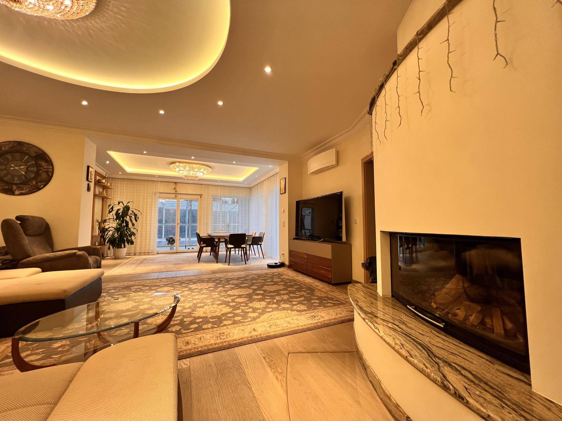 Großzügiges Wohnzimmer mit modernem Kamin, bequemen Sofas und Blick auf den Essbereich.