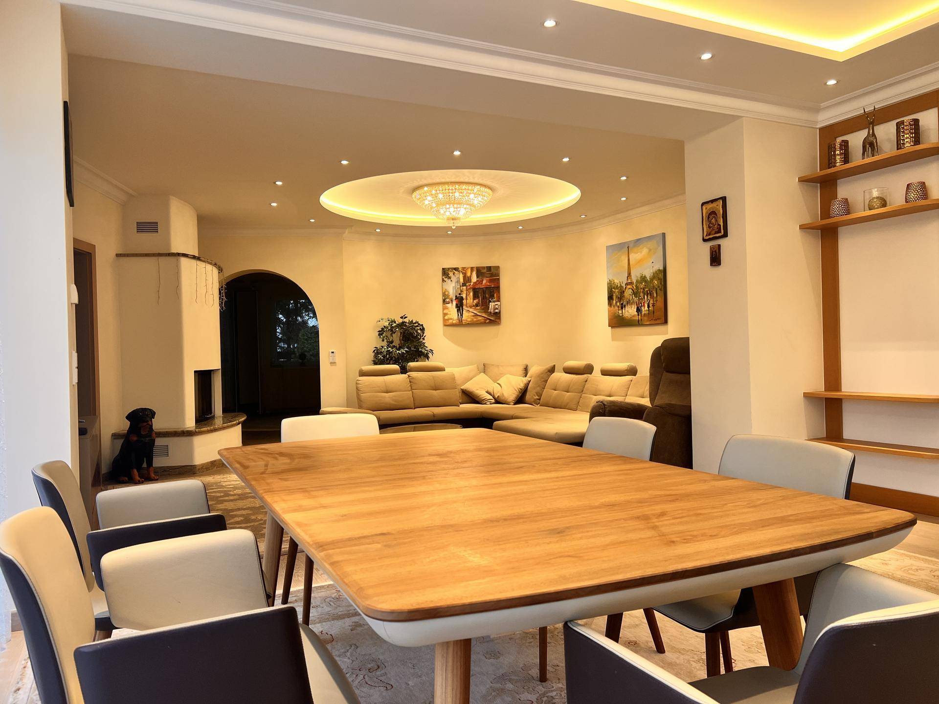 Geräumiger Wohn-Essbereich mit elegantem Holztisch, gemütlicher Sitzecke und modernem Kamin.