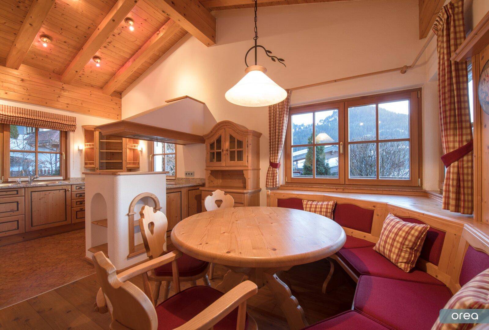 Geräumige Wohnküche im Landhausstil mit Essbereich, Holzeinbauten und Bergblick.