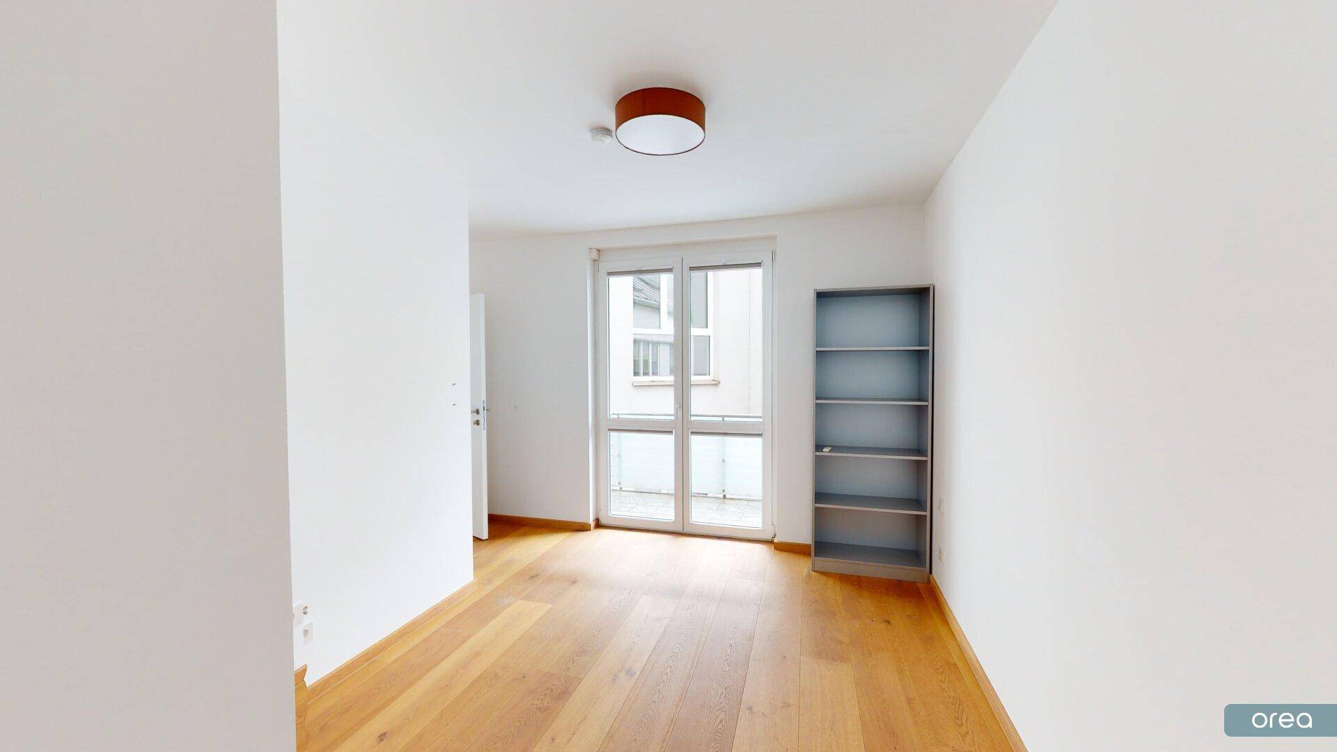 Heller Raum mit Holzboden und Zugang zu einem Außenbereich.