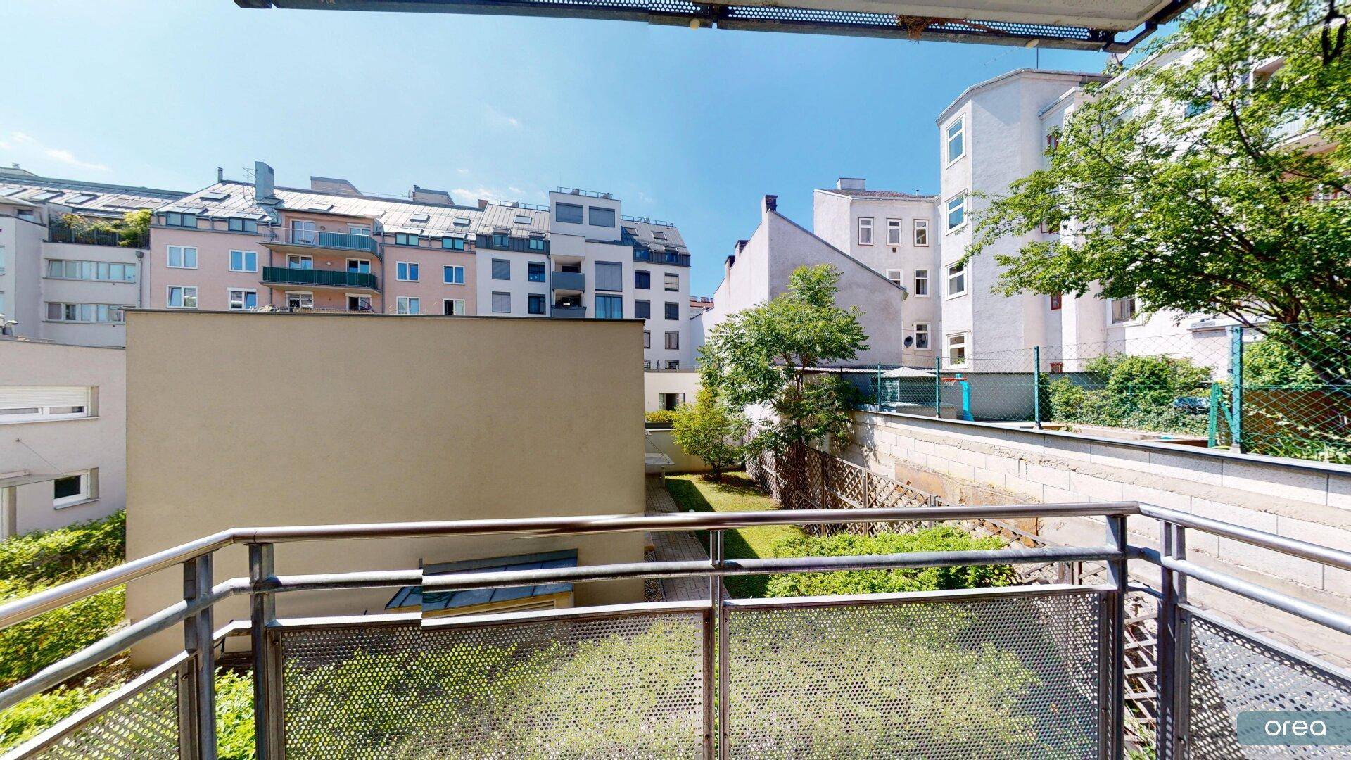 Balkon mit Blick auf die umliegenden Wohngebäude und einen begrünten Innenhof.