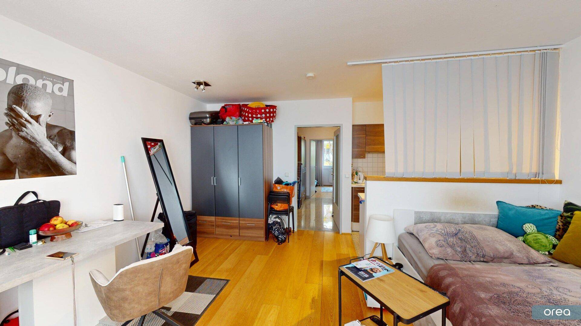 Geräumiges Studio-Apartment mit Holzfußboden, Schreibtisch und integriertem Kleiderschrank.