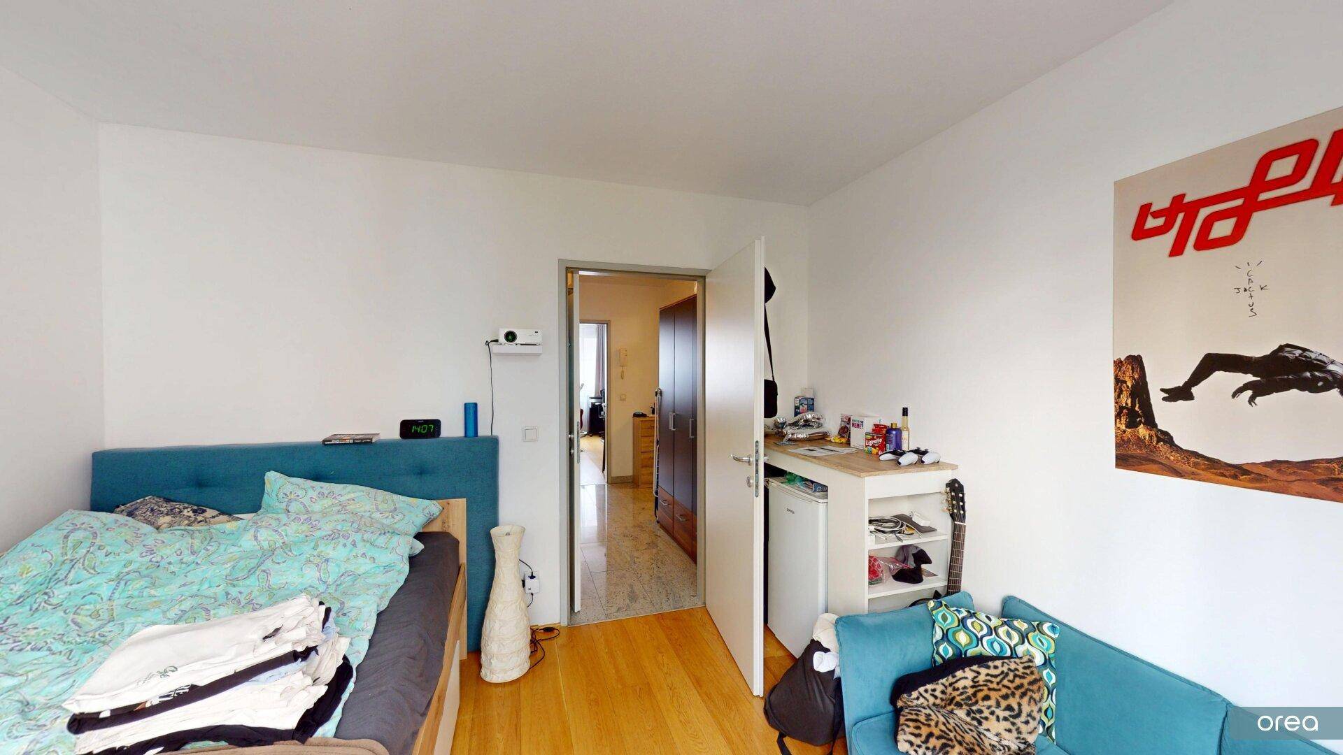 Gemütliches Schlafzimmer mit Einzelbett, Sofa und Zugang zu einem weiteren Raum.