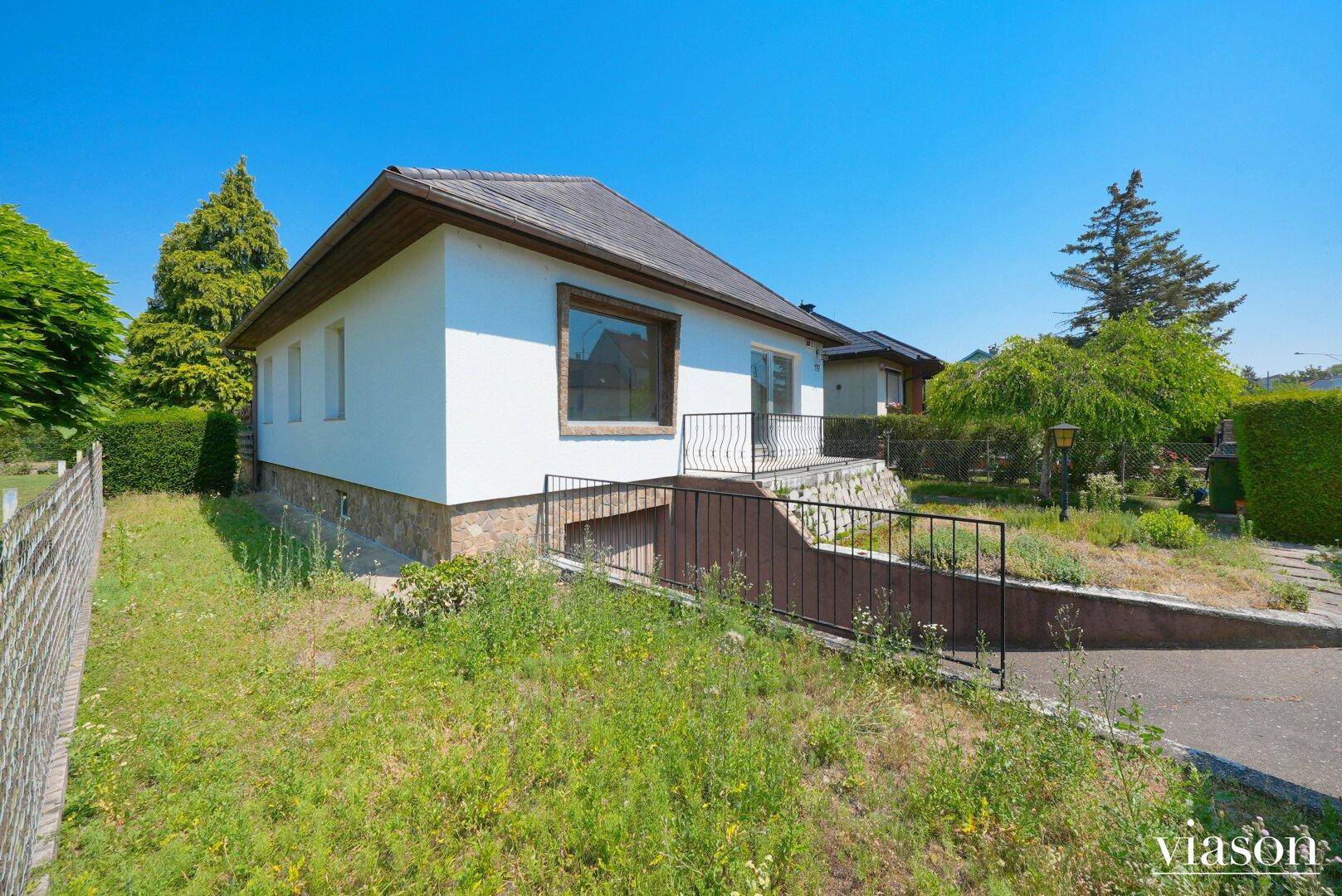 Seitlicher Blick auf das Einfamilienhaus mit Garagenzufahrt und gepflegtem Vorgarten.