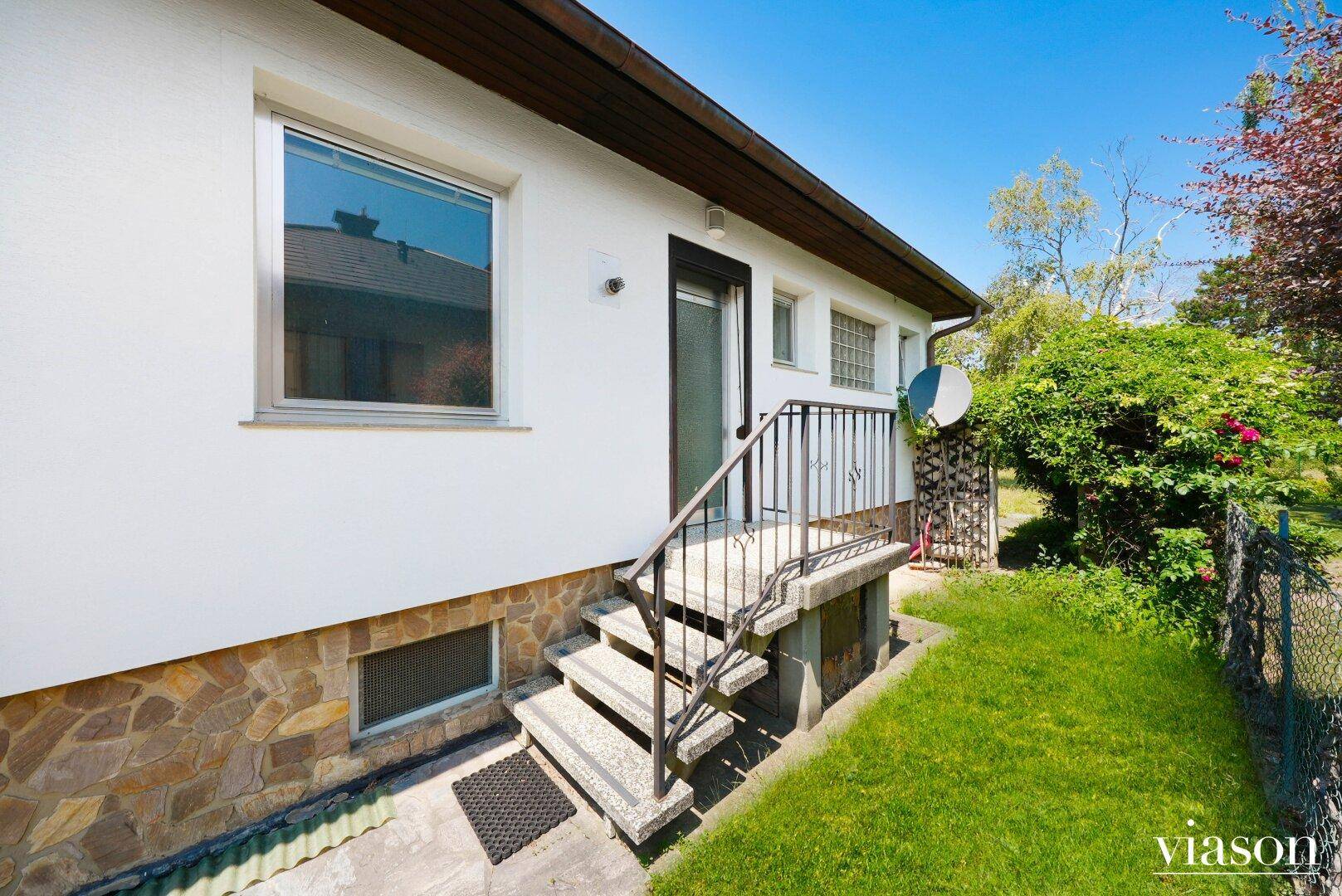 Hinterer Eingangsbereich des Hauses mit Steintreppe und Zugang zum Garten.