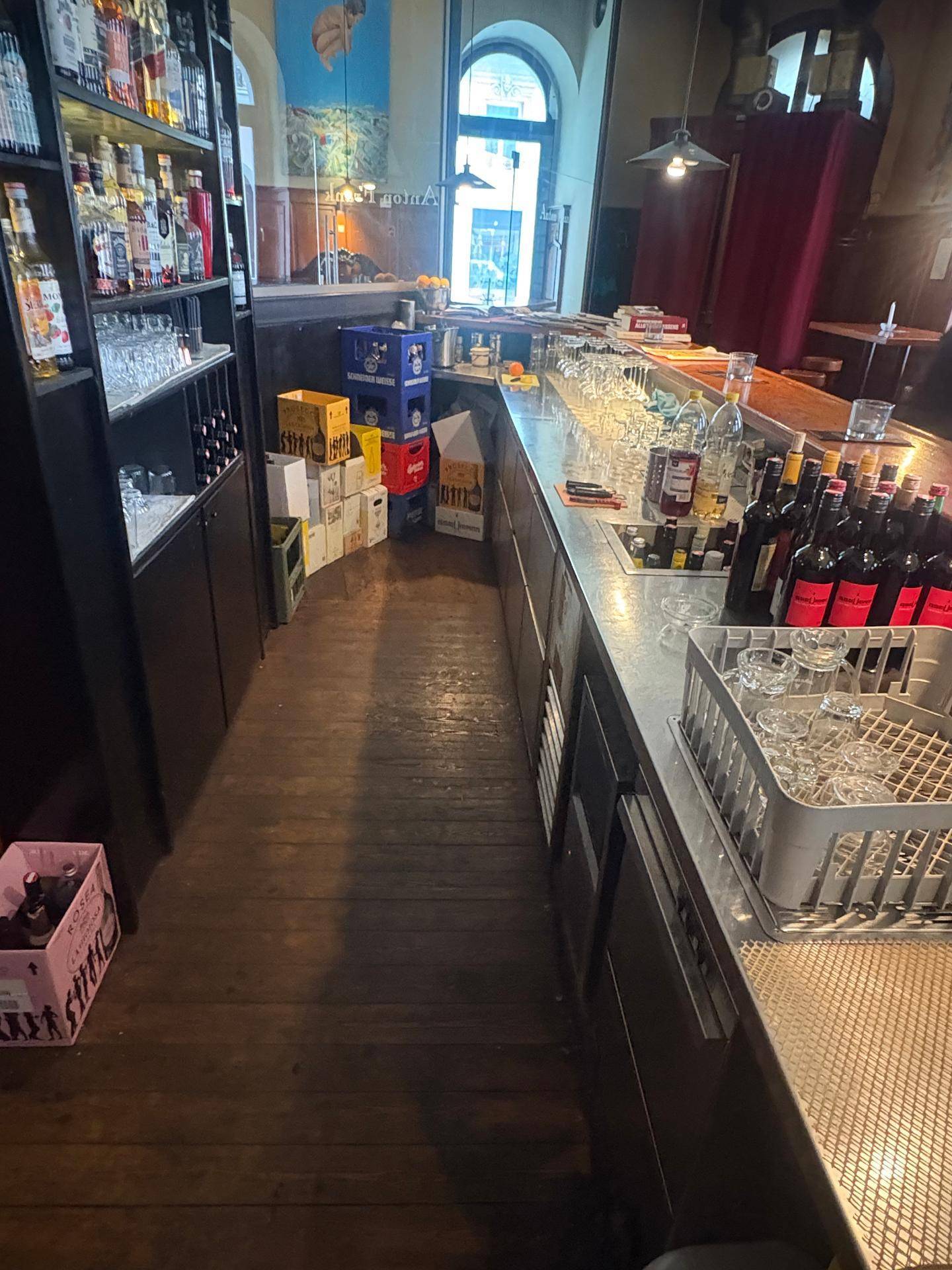 Blick hinter die Bar mit Lagerung für Getränkekisten und Gläsern.