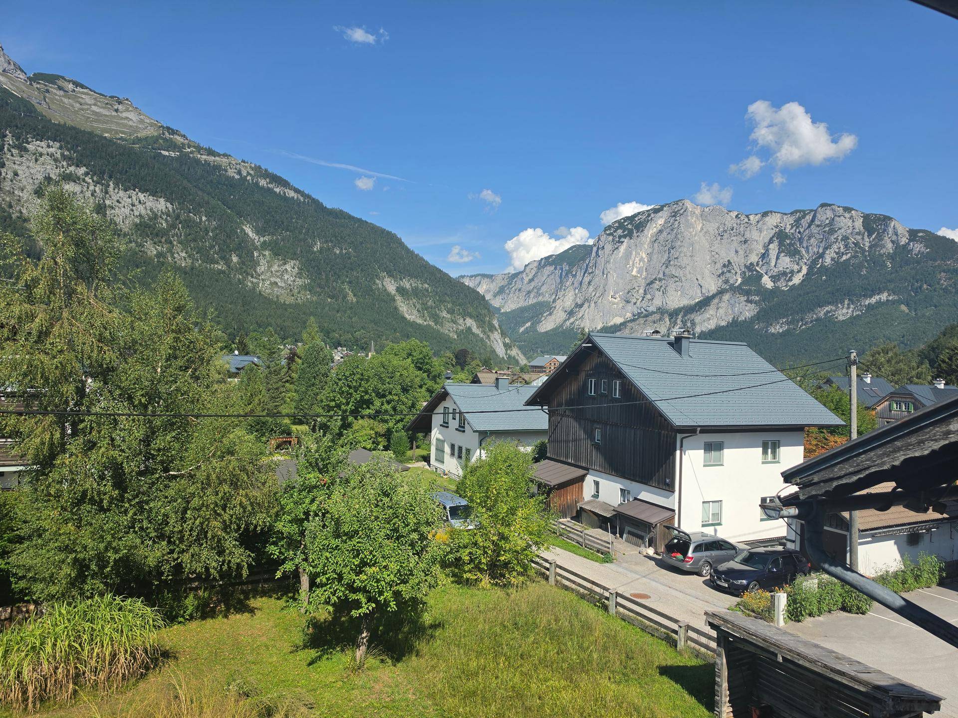 Weitläufiger Ausblick auf die majestätischen Berge und die charmante Wohngegend unter blauem Himmel.