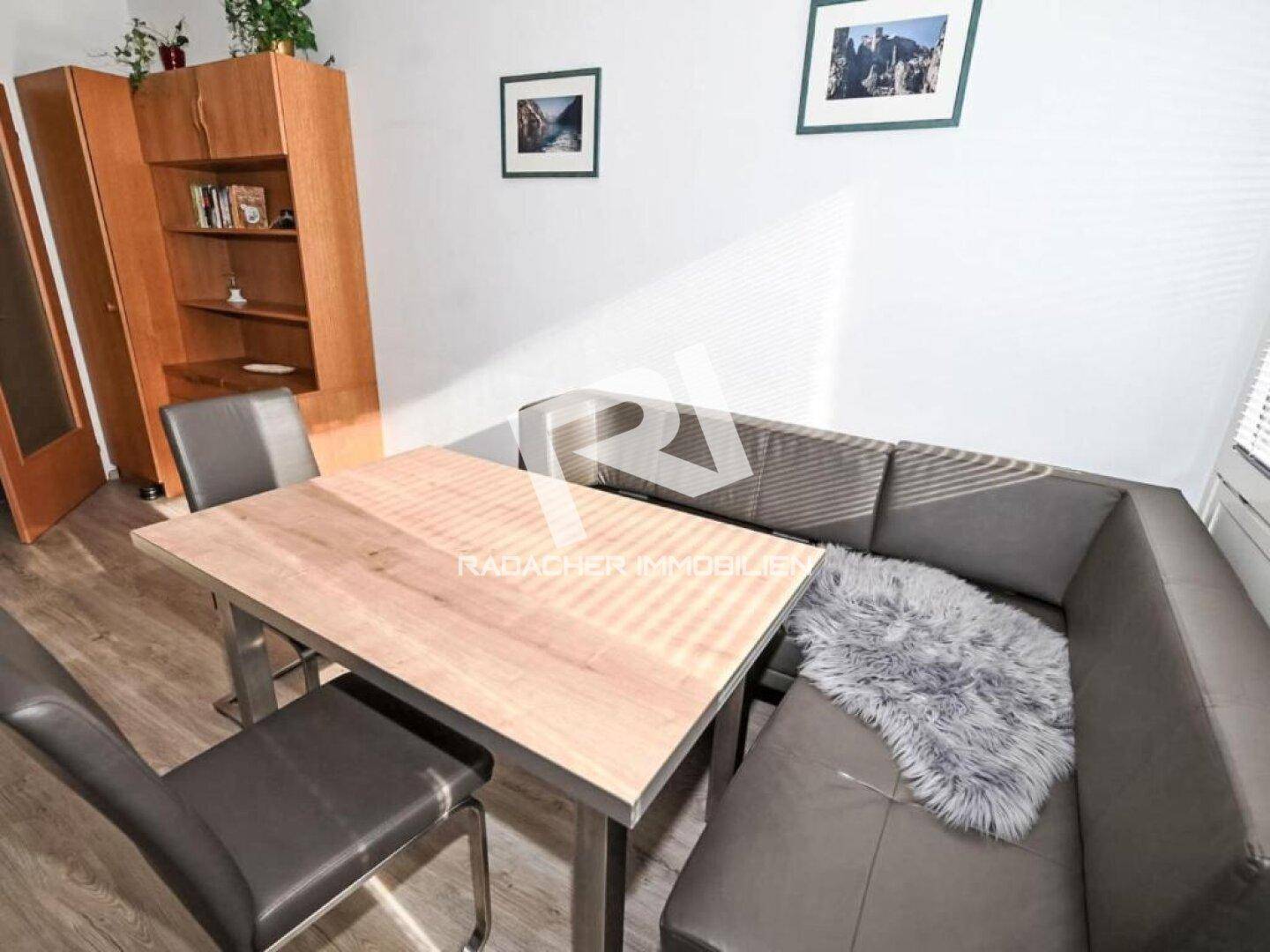 Heller Essbereich mit Eckbank, Holztisch und einem praktischen Holzregal für zusätzlichen Stauraum.