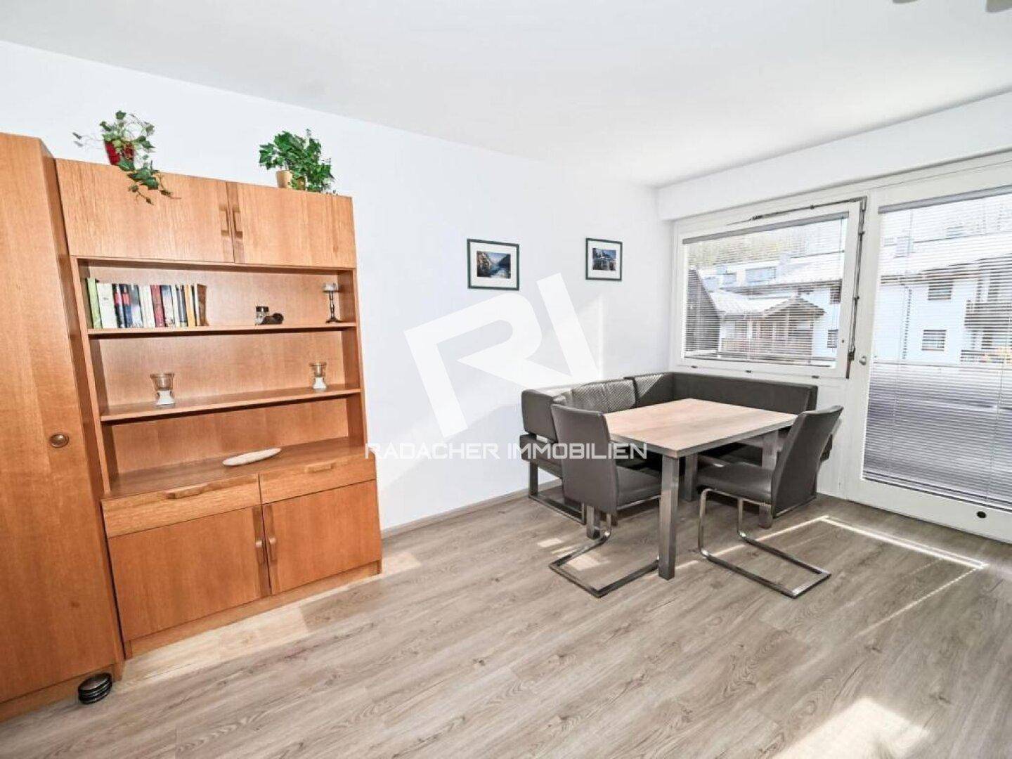 Geräumiger Essbereich mit Eckbank, Holztisch und einem großen Holzschrank, ideal für Familienmahlzeiten.