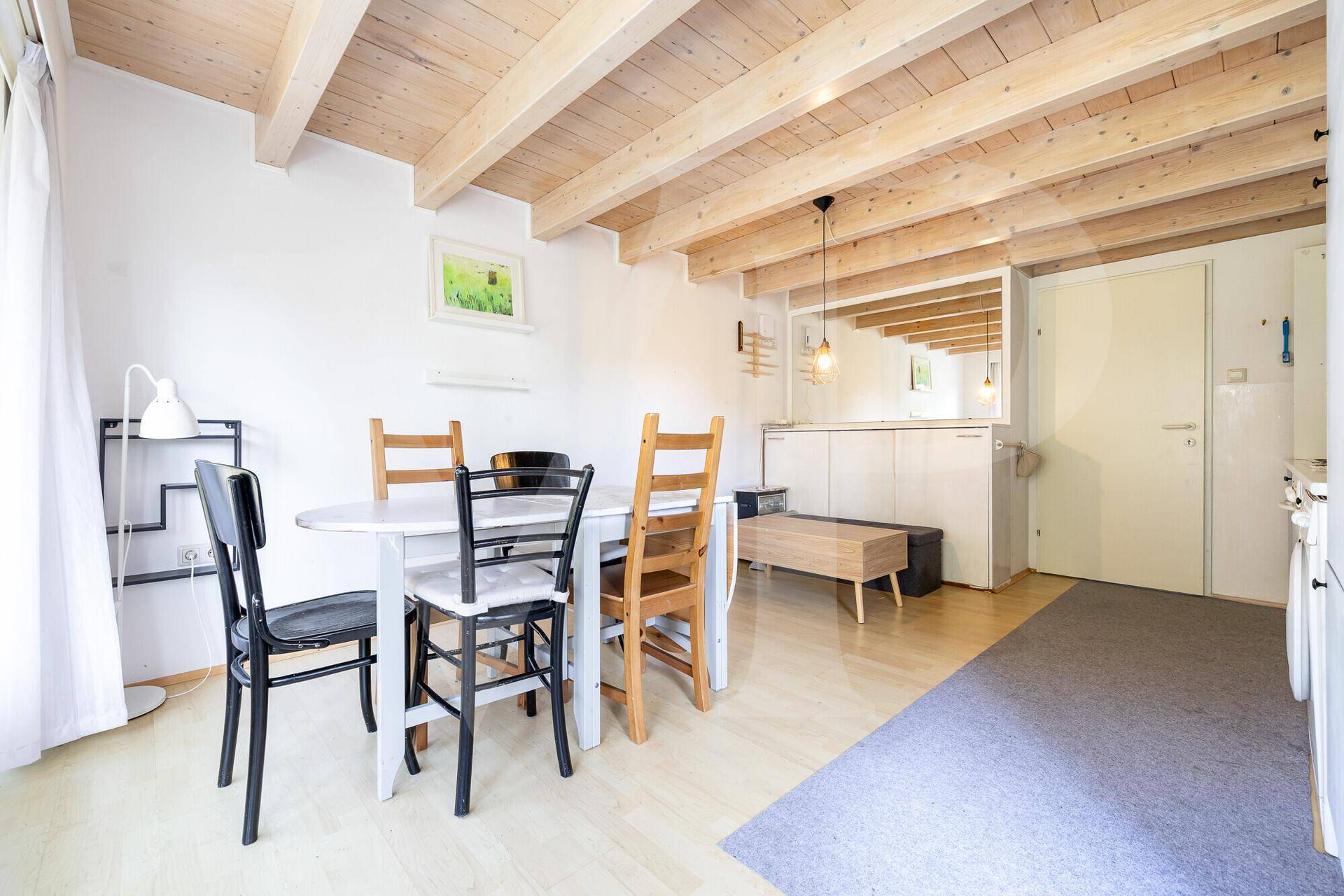 Helles Schlafzimmer im Dachgeschoss mit Holzboden, schrägen Wänden und Balkonzugang.