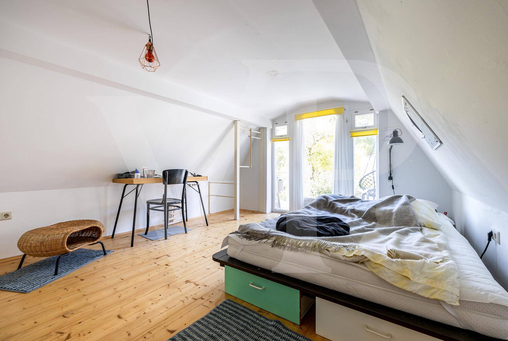 Weitläufiger Blick vom Balkon über den grünen Garten und die bewaldete Umgebung.