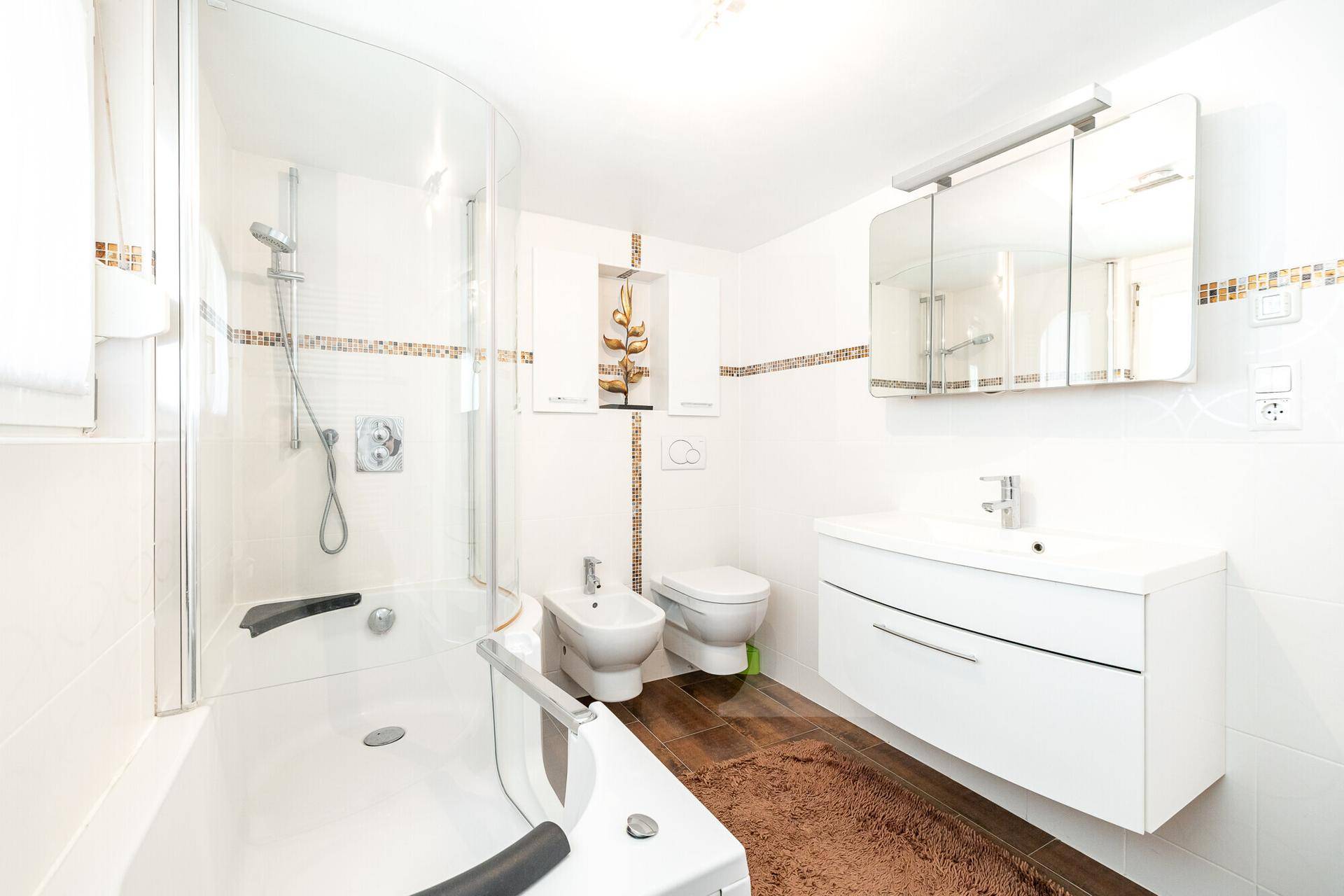 Modernes Badezimmer mit Badewanne, Dusche, Bidet und Einzelwaschbecken.