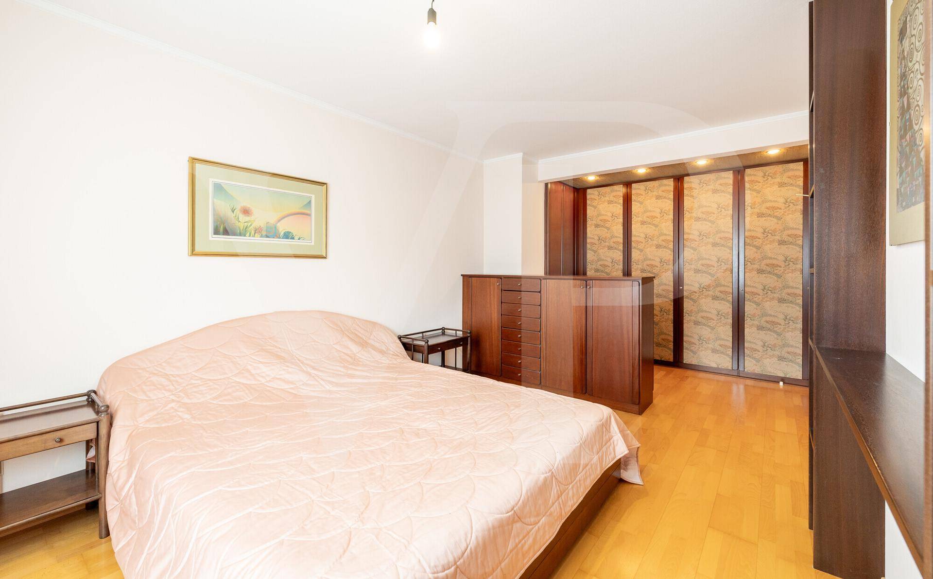 Gemütliches Schlafzimmer mit Doppelbett, Holzmöbeln und praktischen Einbauschränken.