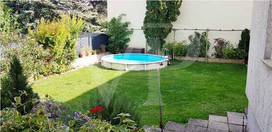 Gepflegter Garten mit Rasenfläche, einem Aufstellpool und einem kleinen Geräteschuppen.