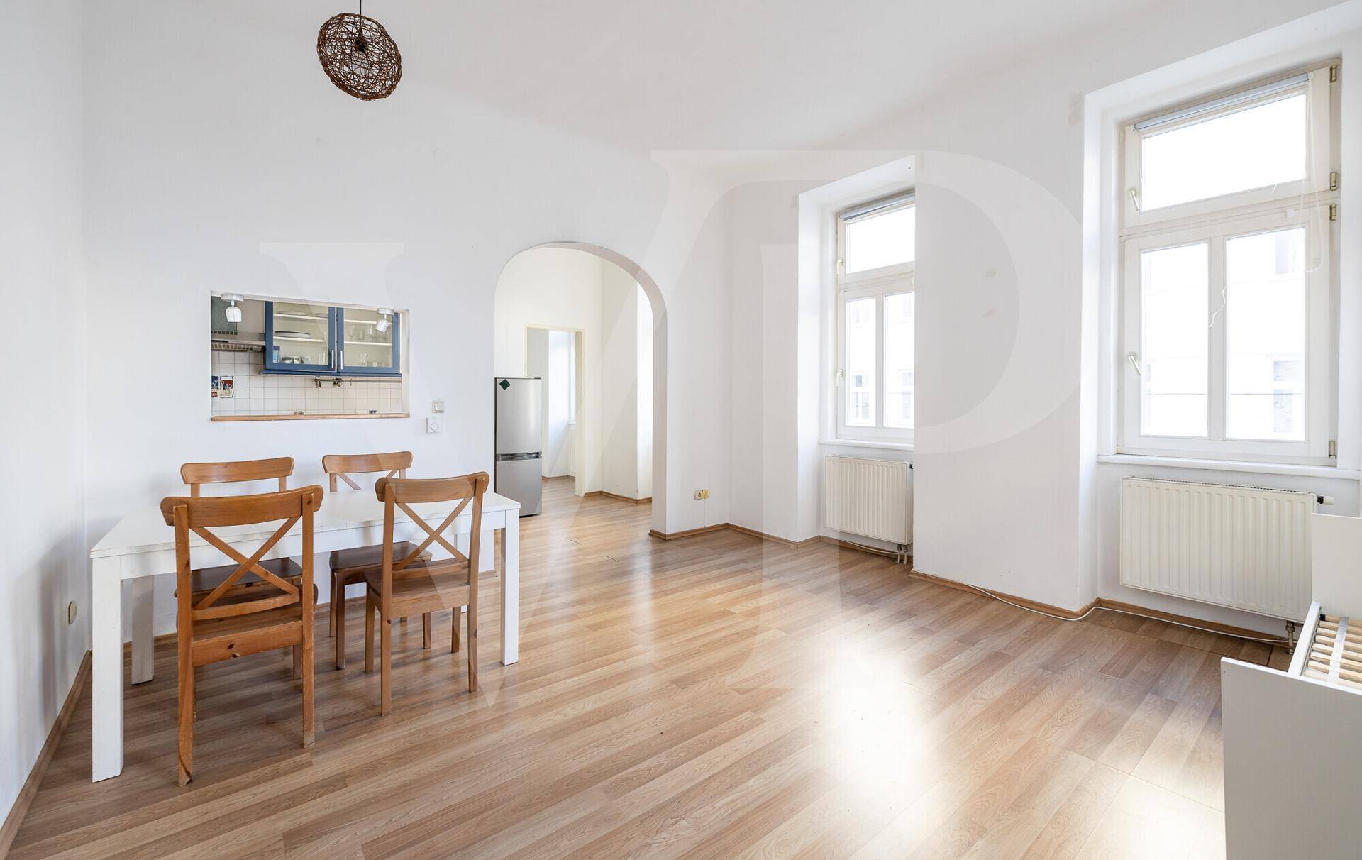 Geräumiger Wohn- und Essbereich mit Holzboden und großen Fenstern für viel Tageslicht.