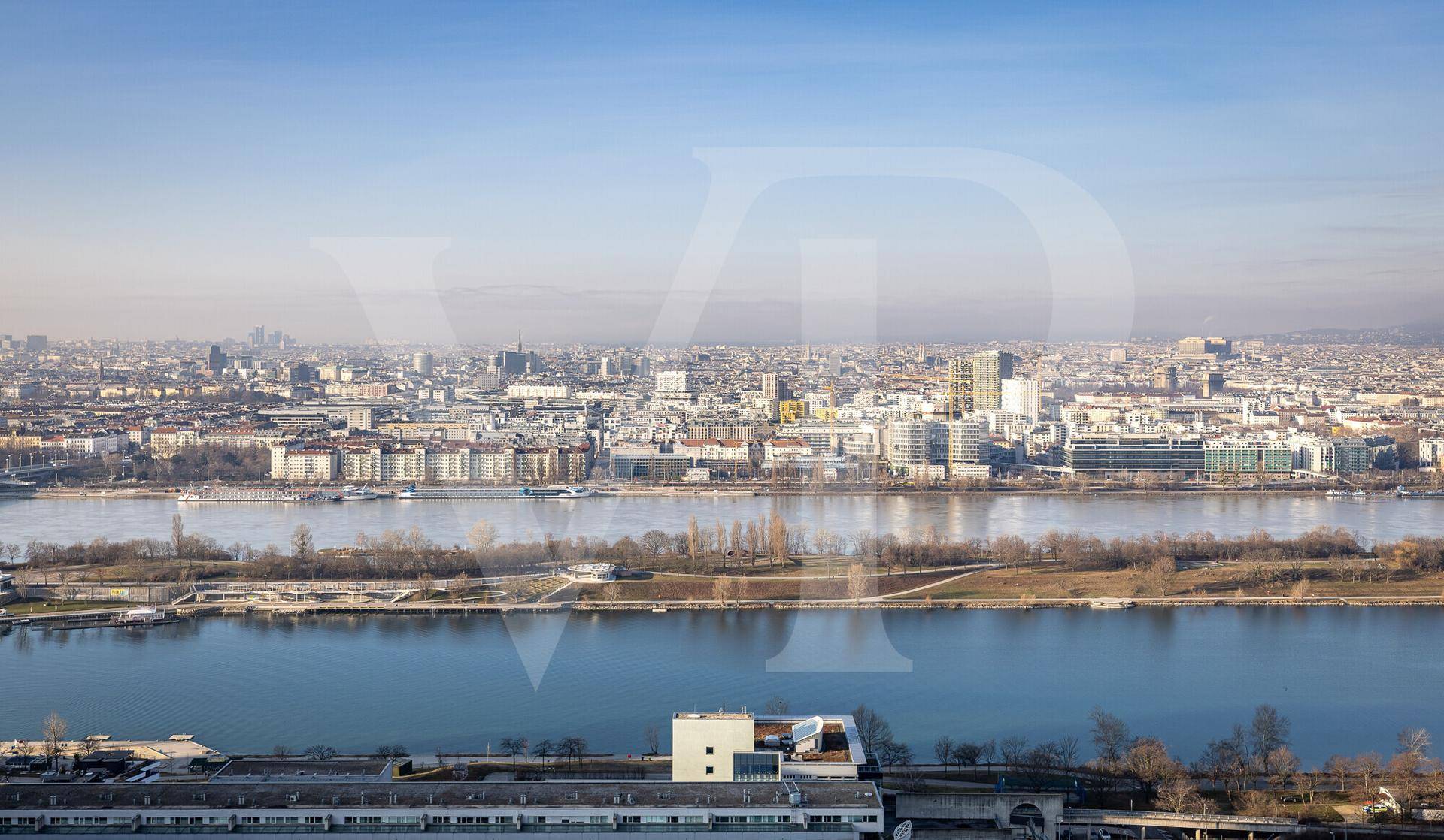 Breiter Ausblick über die Stadtlandschaft mit dem Fluss und der urbanen Bebauung am Horizont.