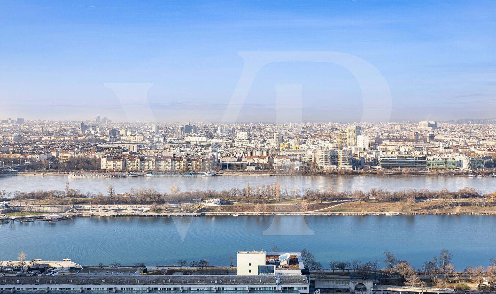 Panoramischer Blick auf die Stadt mit dem Fluss und der weiten Bebauung unter klarem Himmel.