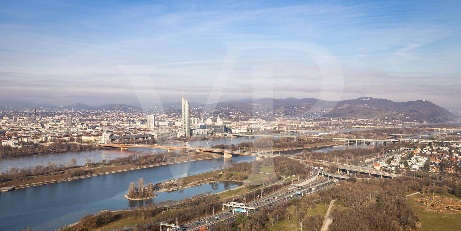 Panoramablick über die Stadt mit Fluss, Brücken und den umliegenden Bergen am Horizont.