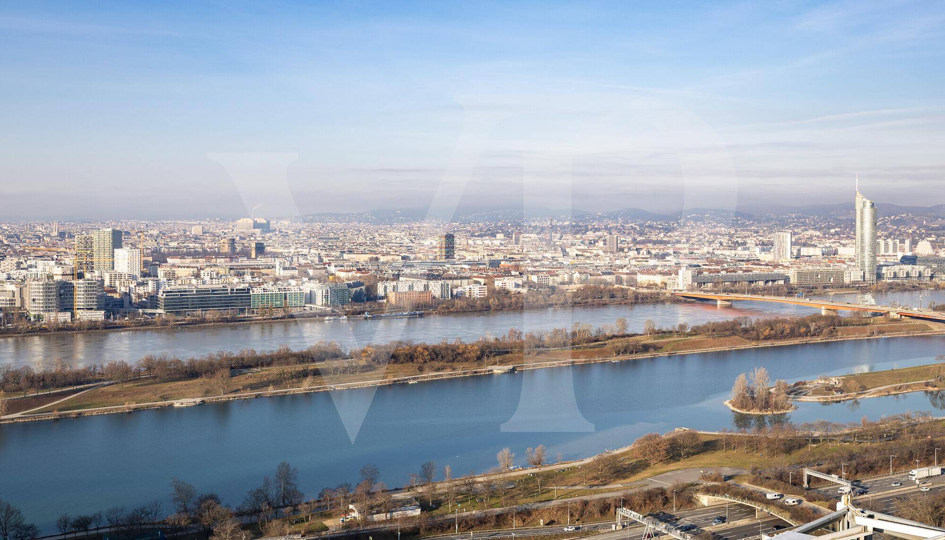 Breiter Ausblick über die Stadtlandschaft mit dem Fluss und der urbanen Bebauung am Horizont.