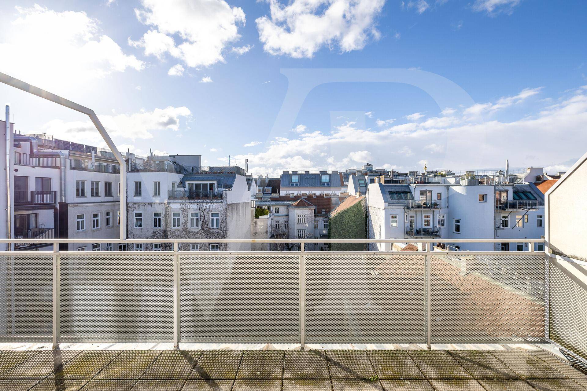 Große Dachterrasse mit Metallgeländer und weitem Blick über die städtische Umgebung.