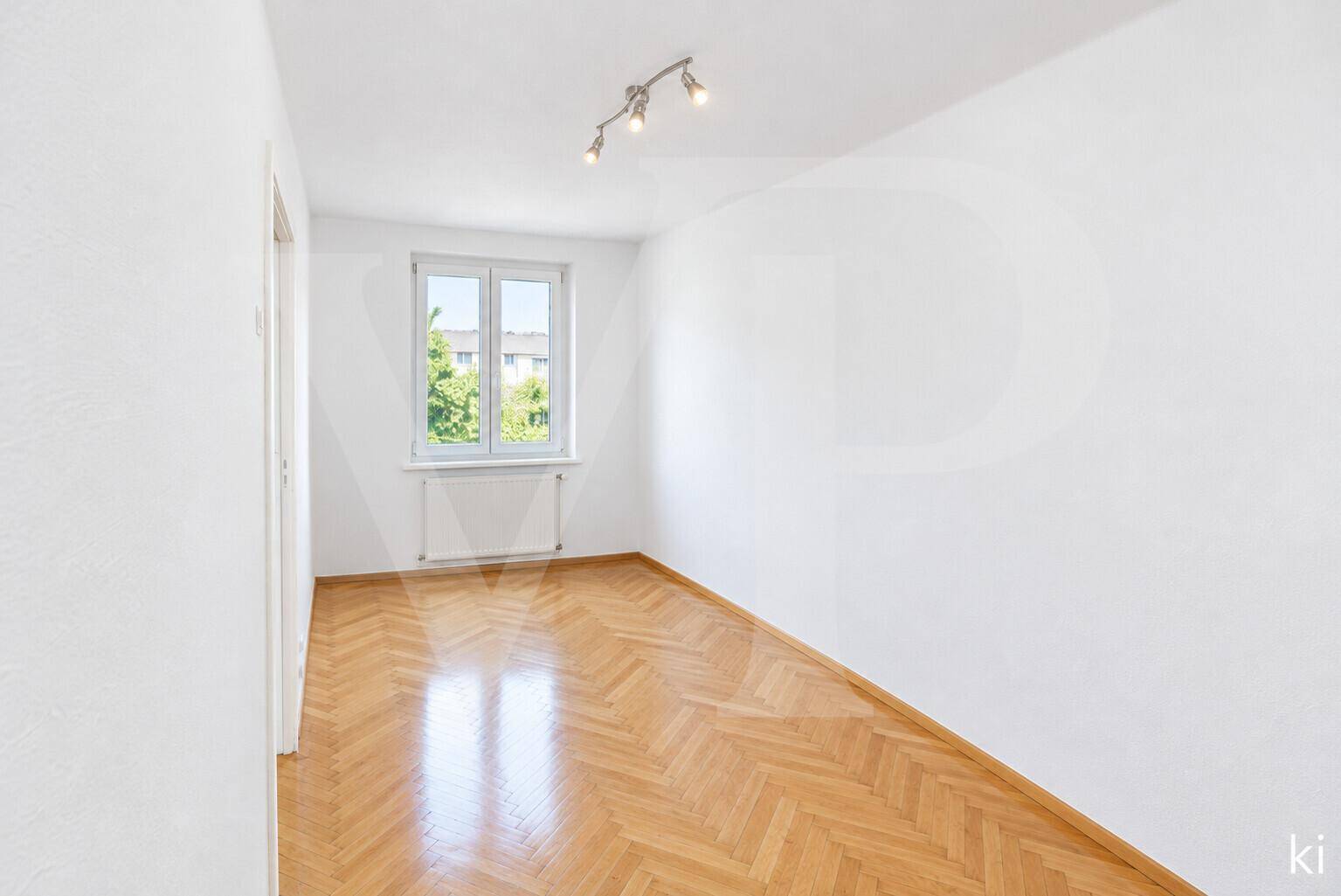 Schlafzimmer mit orangefarbenen Wänden, großem Spiegelschrank und klassischem Fischgrätparkett.