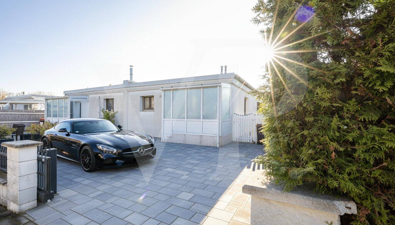 Vorderansicht des Hauses mit gepflasterter Einfahrt und geparktem Auto.