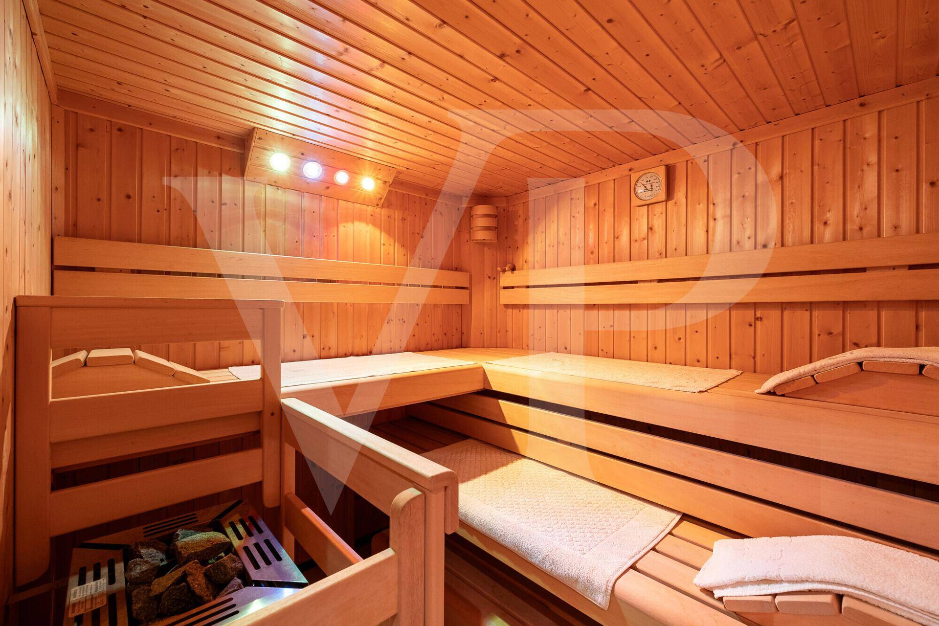 Traditionelle Holzsauna mit mehreren Bänken und einem Heizofen für Entspannung.