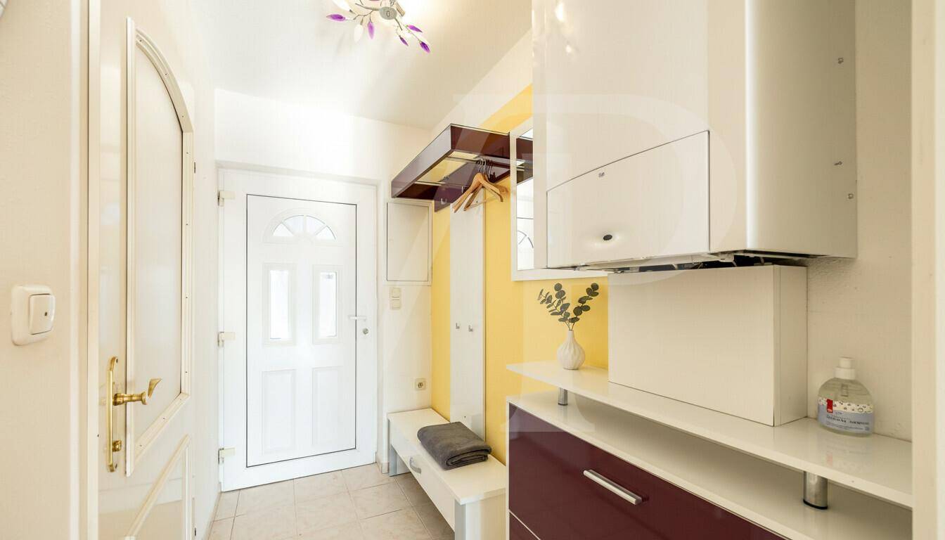 Eingangsbereich mit Garderobe und Heizungsanlage an der Wand.