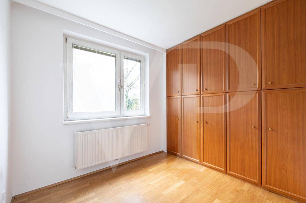Helles Zimmer mit Parkettboden und praktischen Einbauschränken entlang der Wand.
