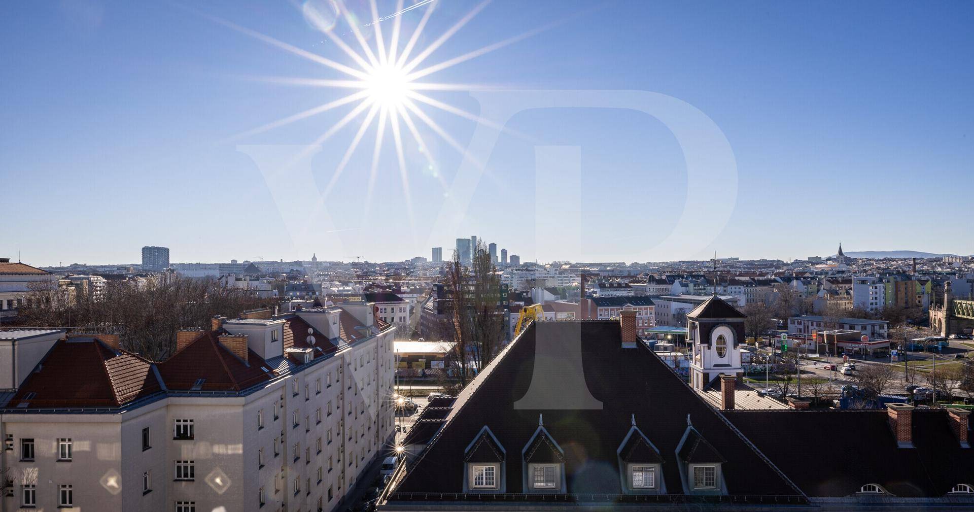 Panoramablick über die Stadt mit historischen Gebäuden und moderner Skyline unter strahlendem Himmel.