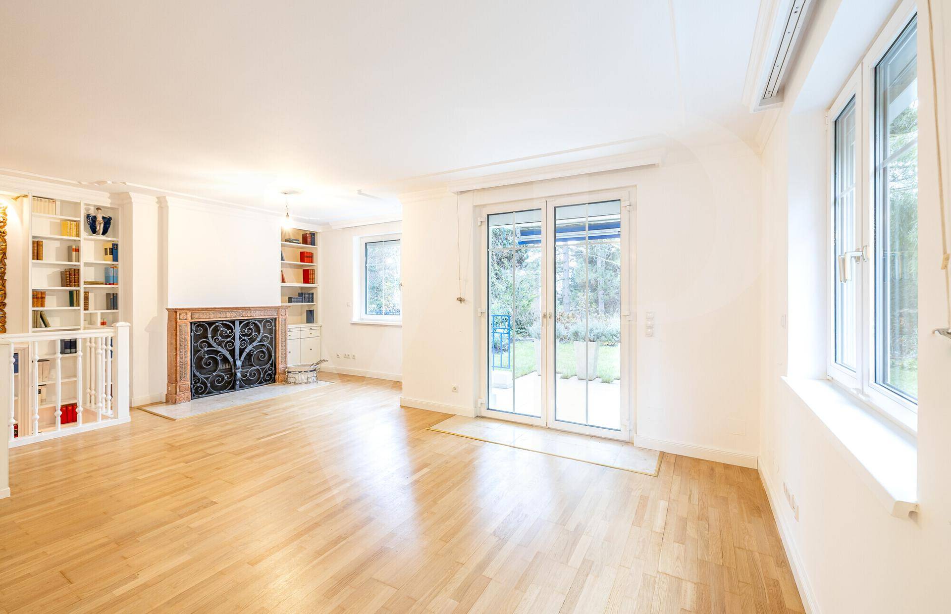 Lichtdurchflutetes Wohnzimmer mit Parkettboden und direktem Zugang zur Terrasse und zum Garten.