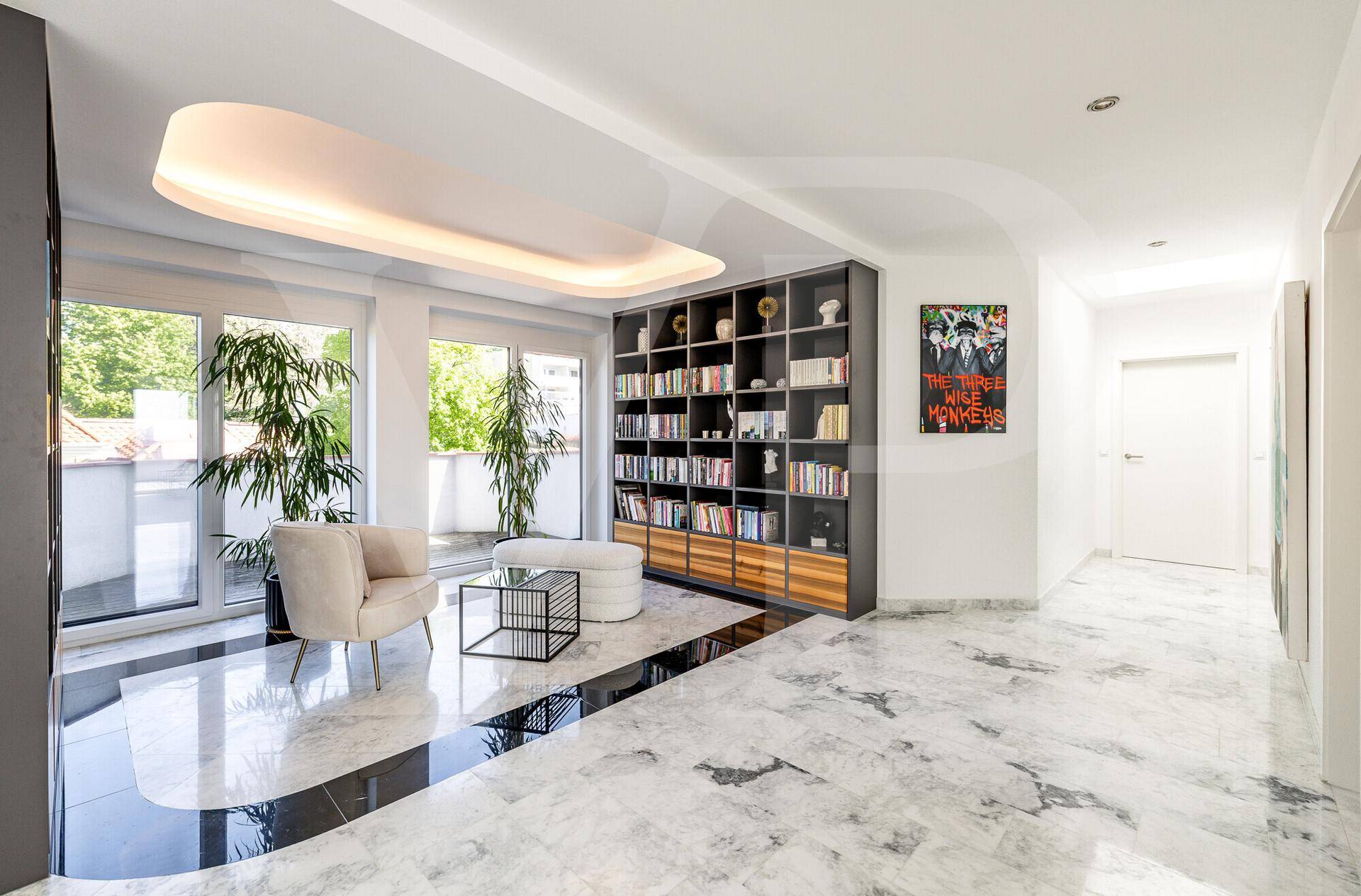 Helle Bibliothek mit Marmorboden, Bücherregalen und Zugang zu einer Außenterrasse.