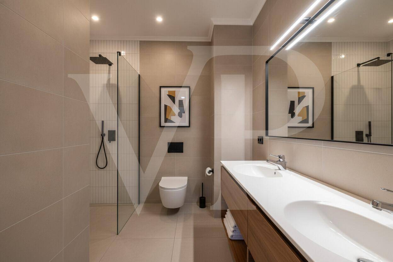 Modernes Badezimmer mit begehbarer Dusche, Doppelwaschbecken und großem Spiegel in hellen Farbtönen.