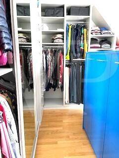 Begehbarer Kleiderschrank mit Regalen und Hängestangen, optimiert für viel Stauraum.