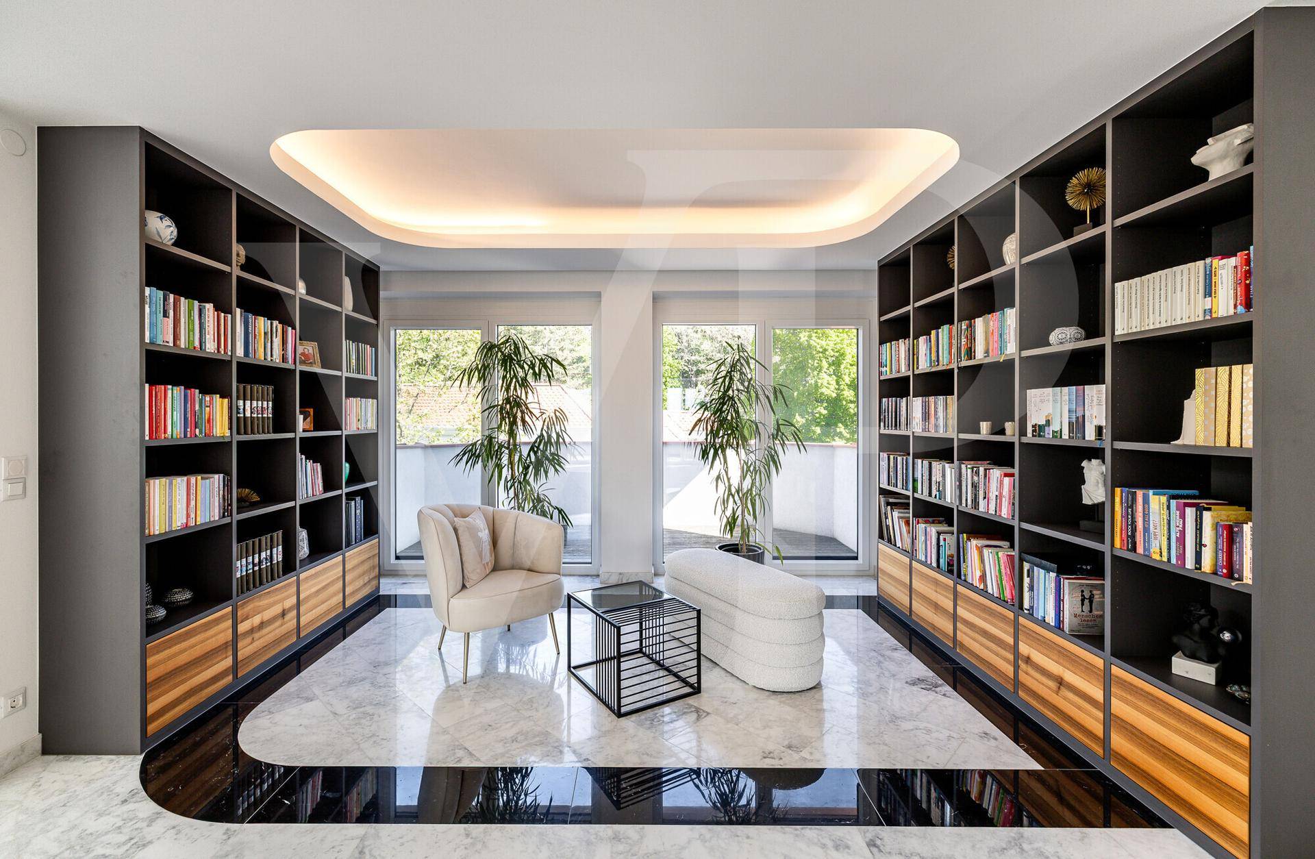 Stilvolle Bibliothek mit raumhohen Bücherregalen, Marmorboden und bequemen Sitzgelegenheiten.