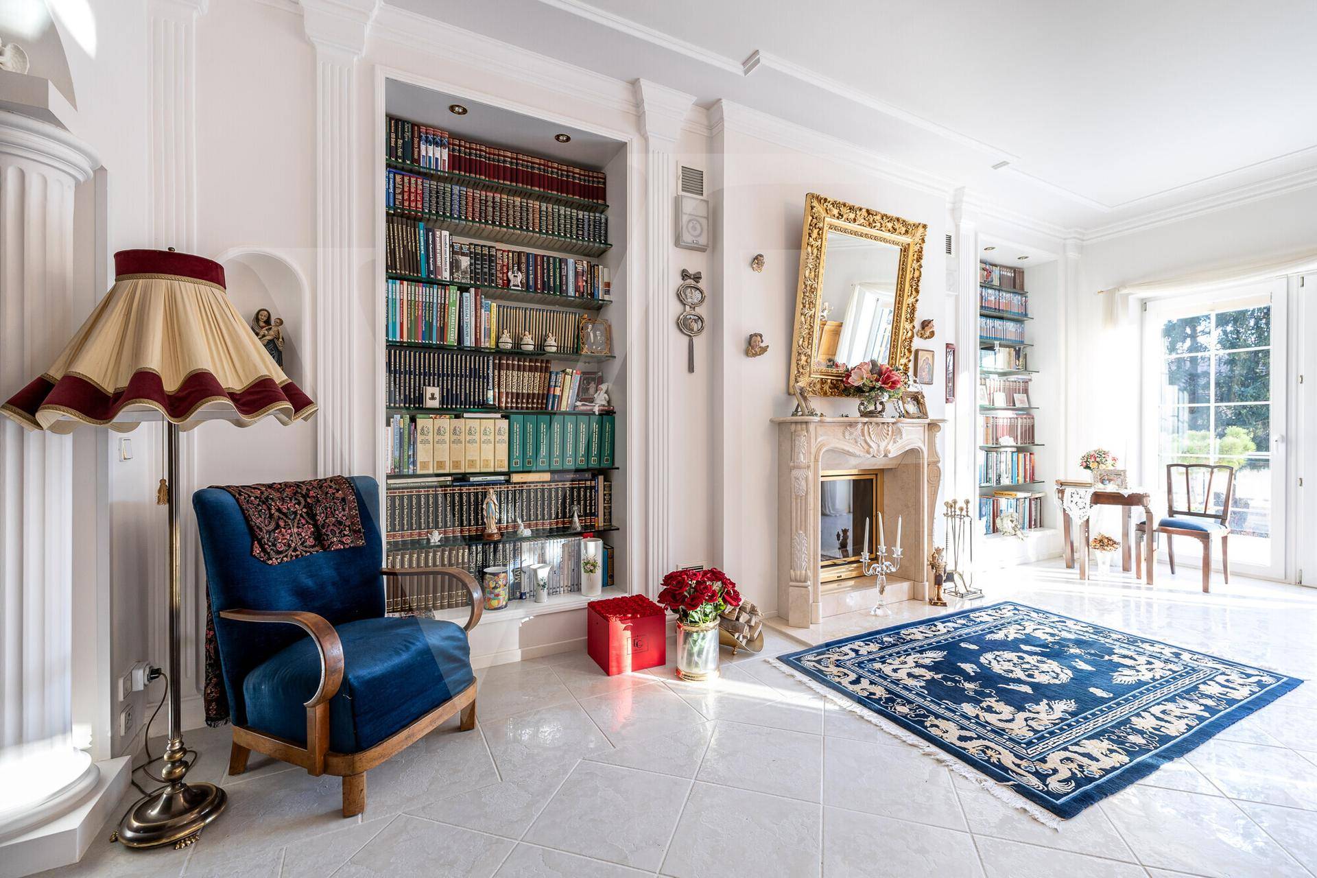 Gemütliche Leseecke mit eingebauten Bücherregalen, klassischem Sessel und Kamin.