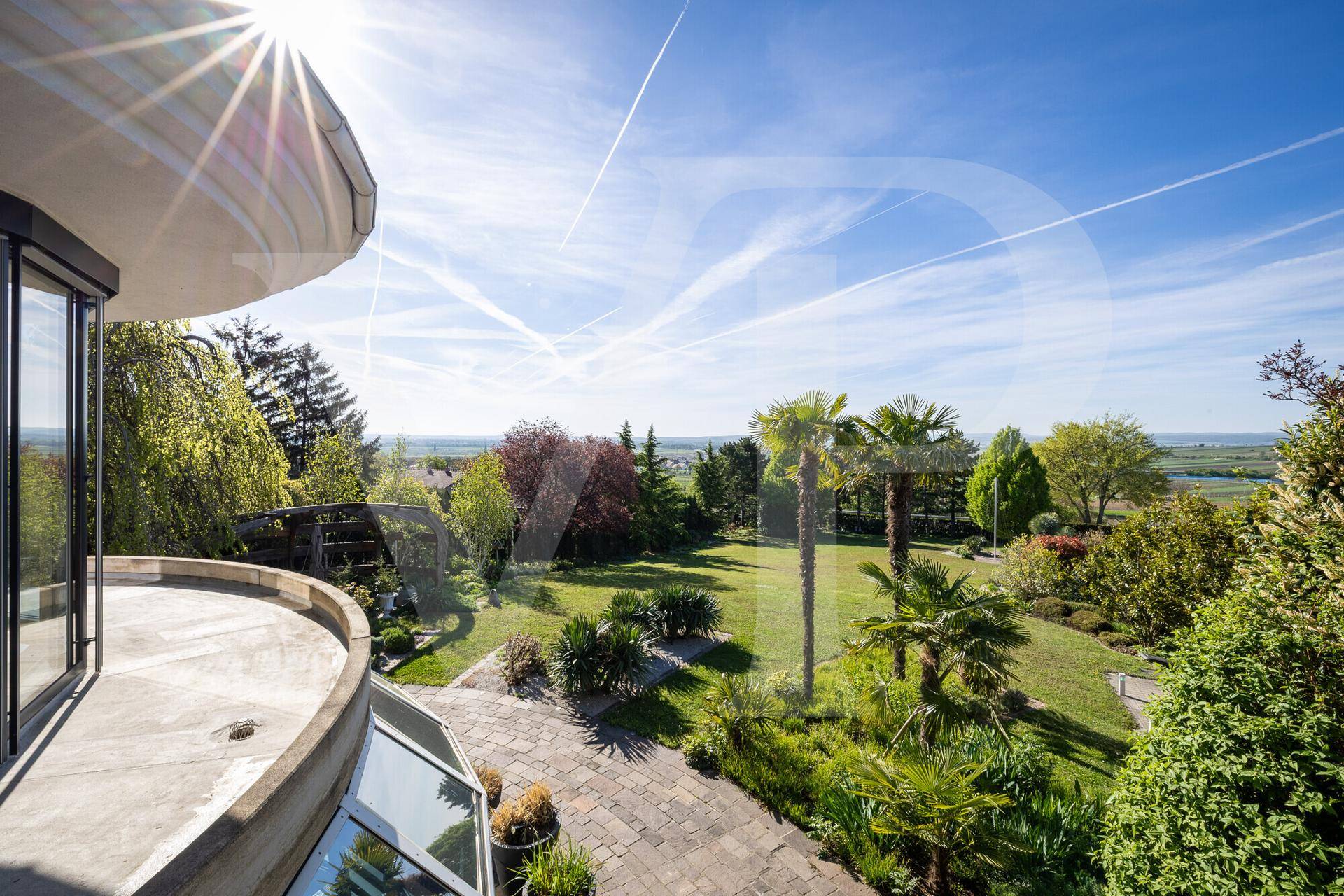 Panoramablick von der Terrasse auf den weitläufigen Garten und die umliegende Landschaft.